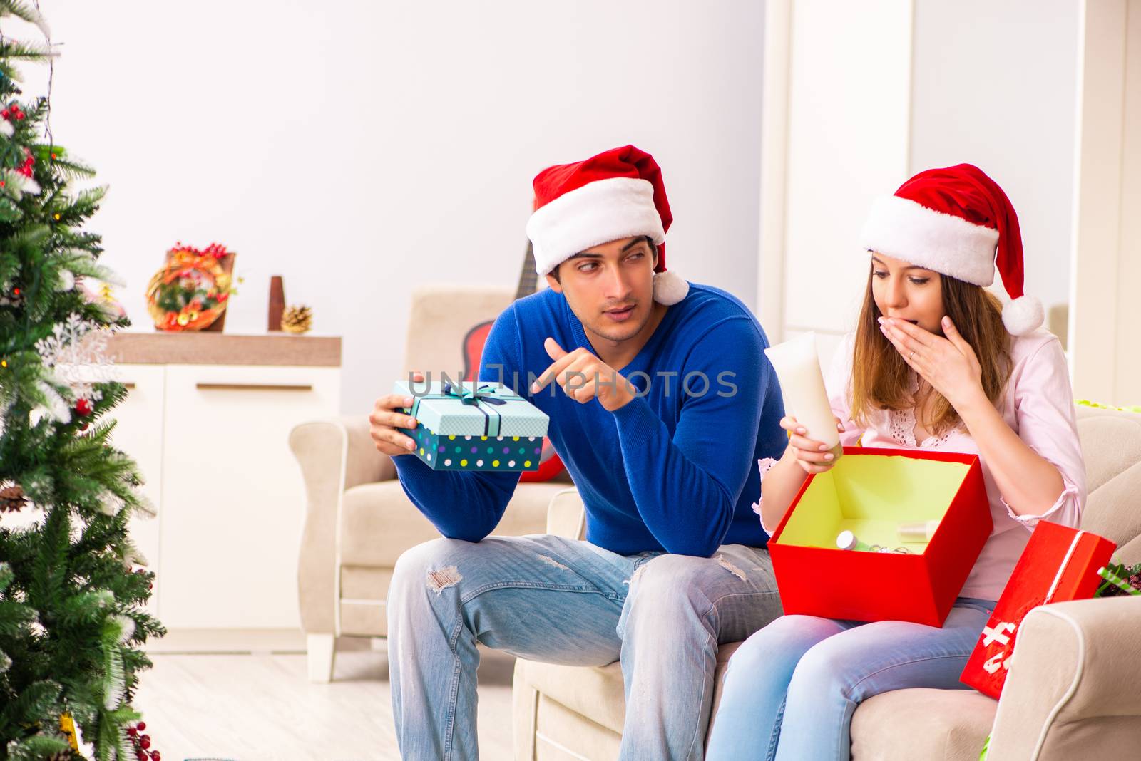 Young couple celebrating christmas at home by Elnur