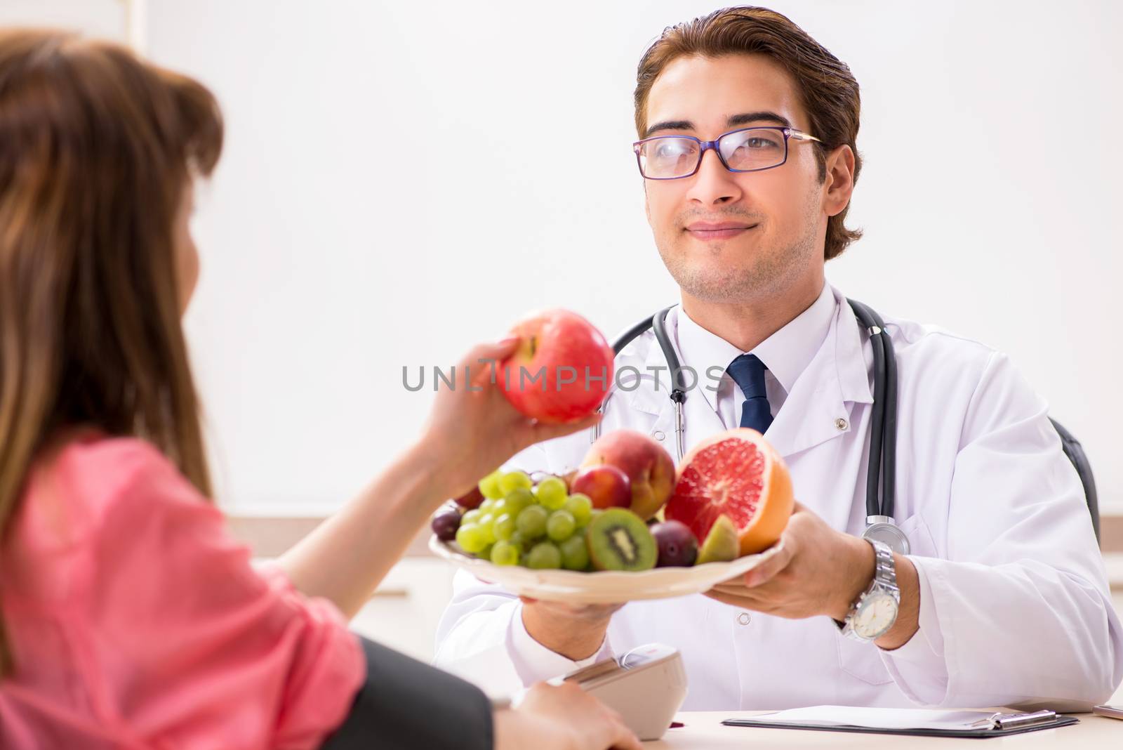 Pregnant woman visiting doctor discussing healthy diet