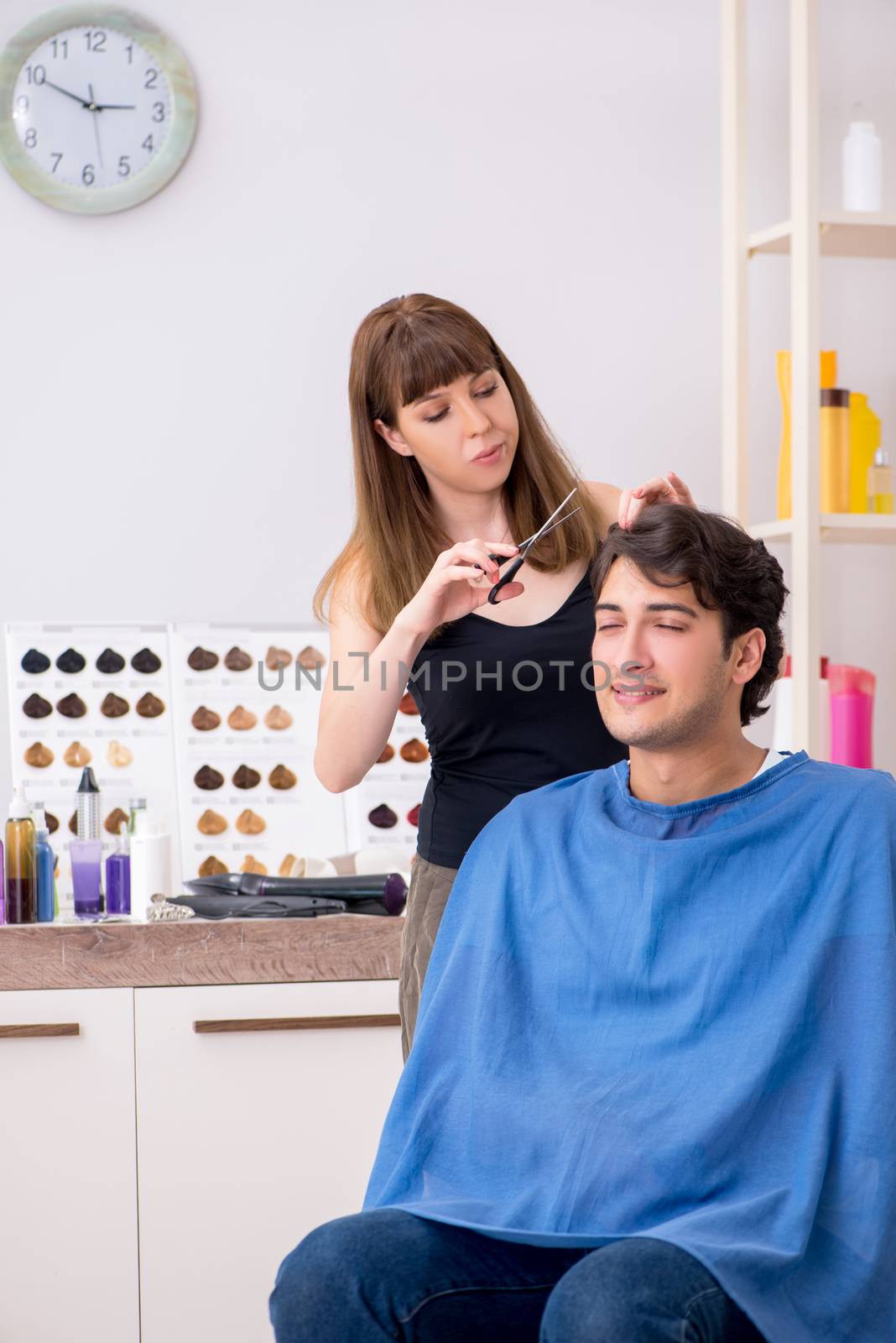 Young attracrive man visiting female barber 