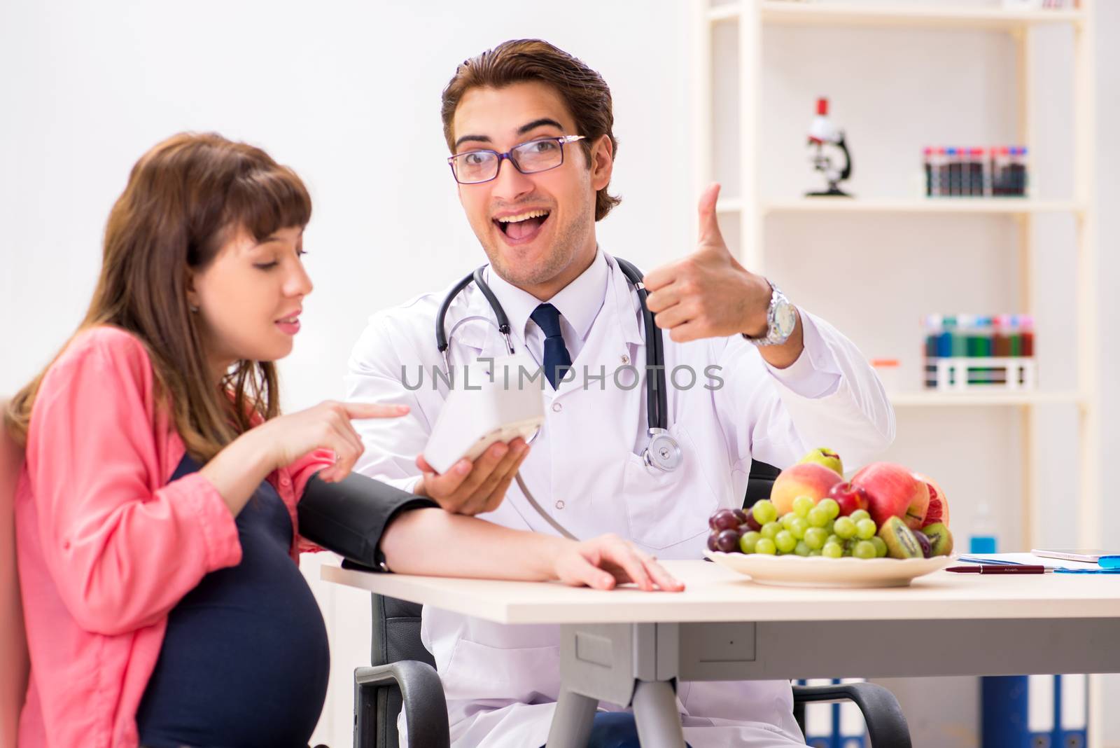 Pregnant woman visiting doctor discussing healthy diet