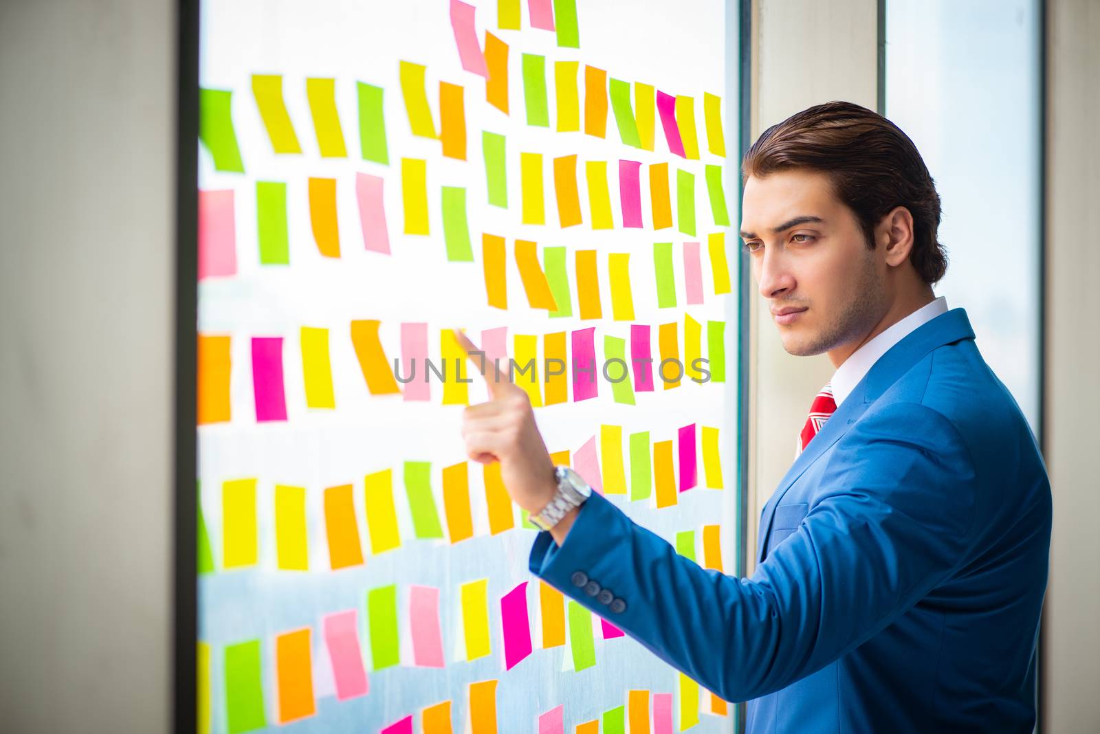 Young handsome employee with many conflicting priorities   