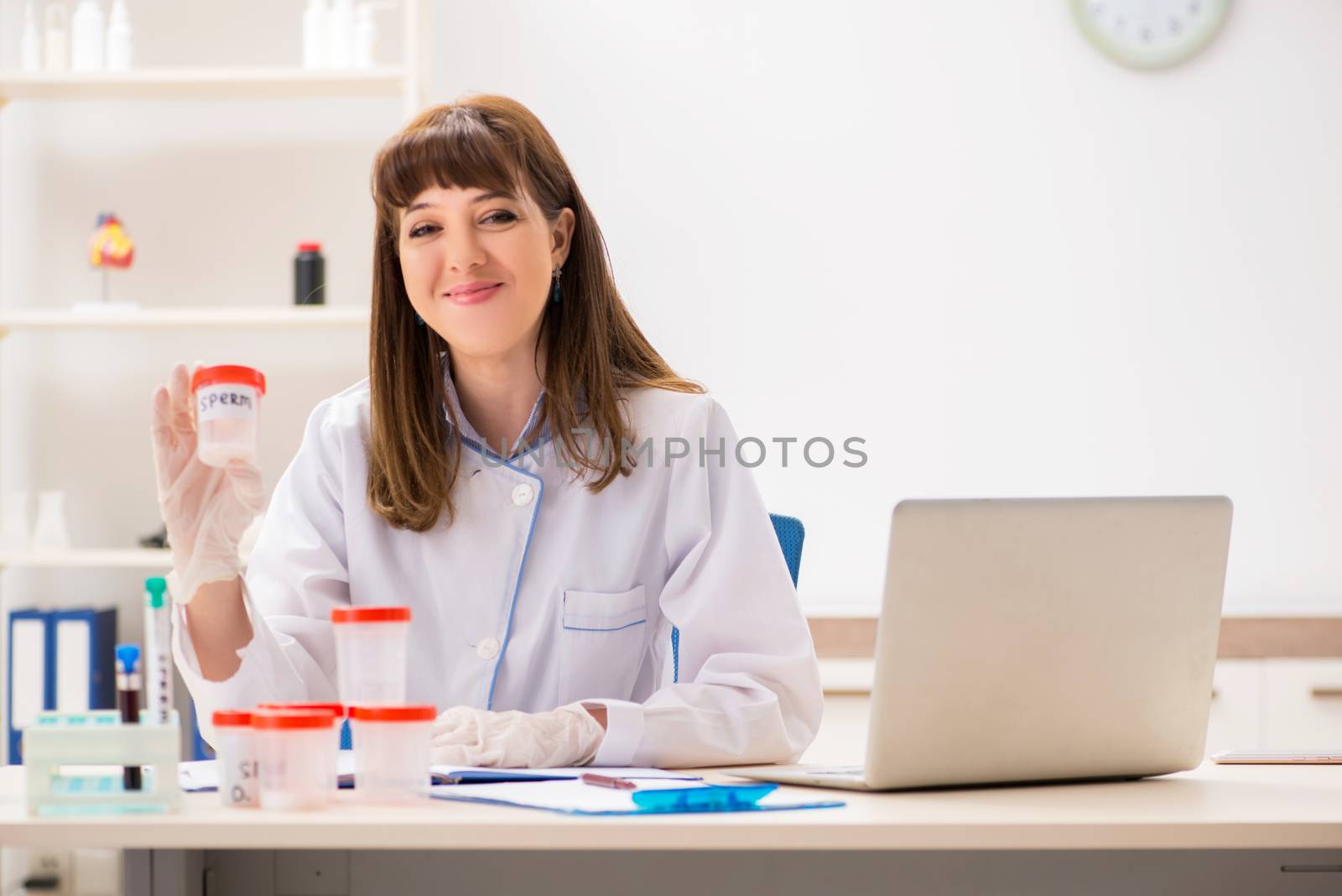 Doctor in sperm bank with sample bottle