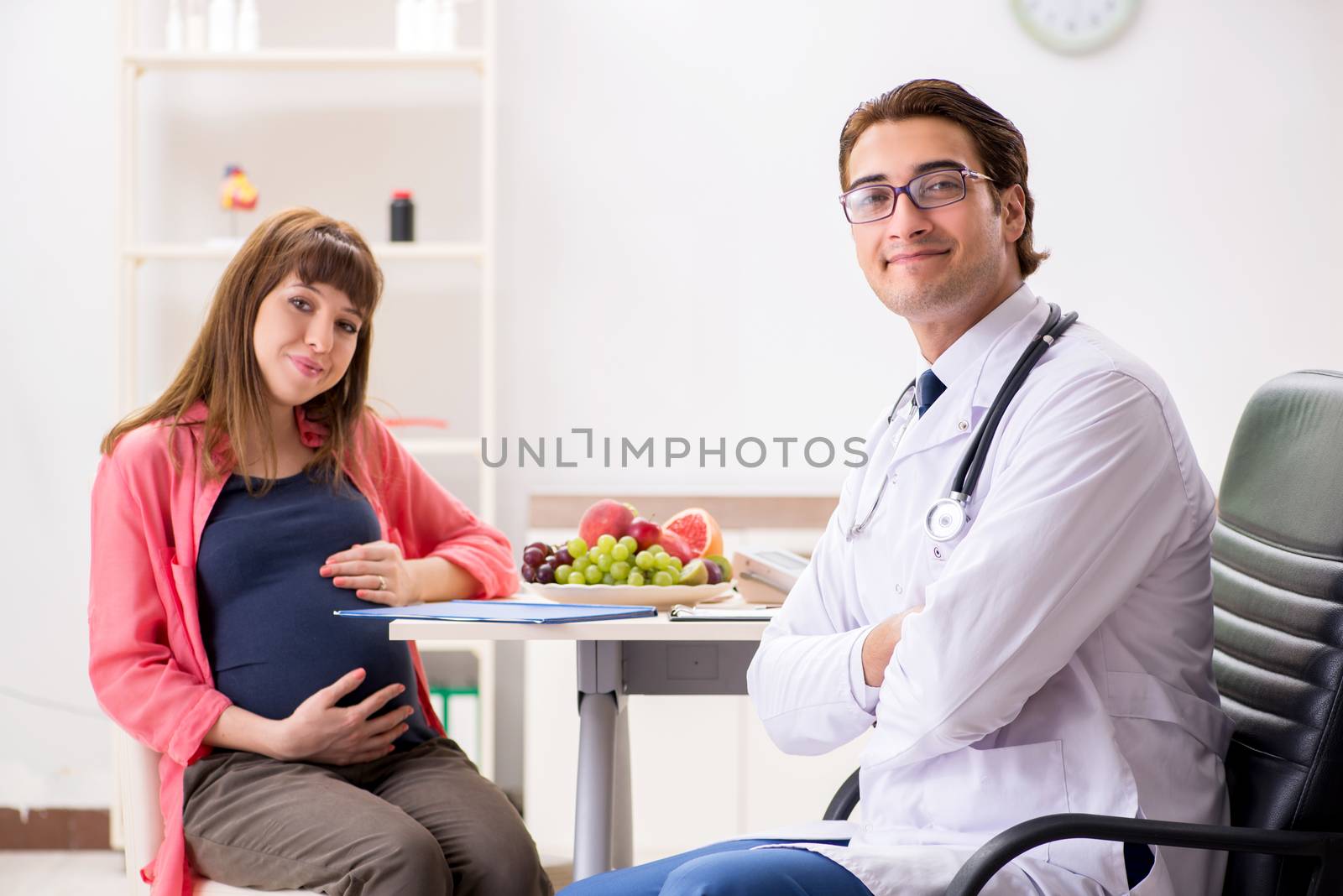 Pregnant woman visiting doctor discussing healthy diet