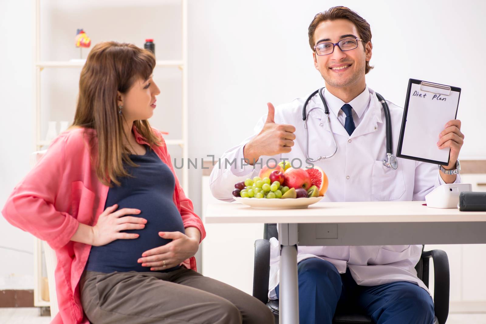 Pregnant woman visiting doctor discussing healthy diet