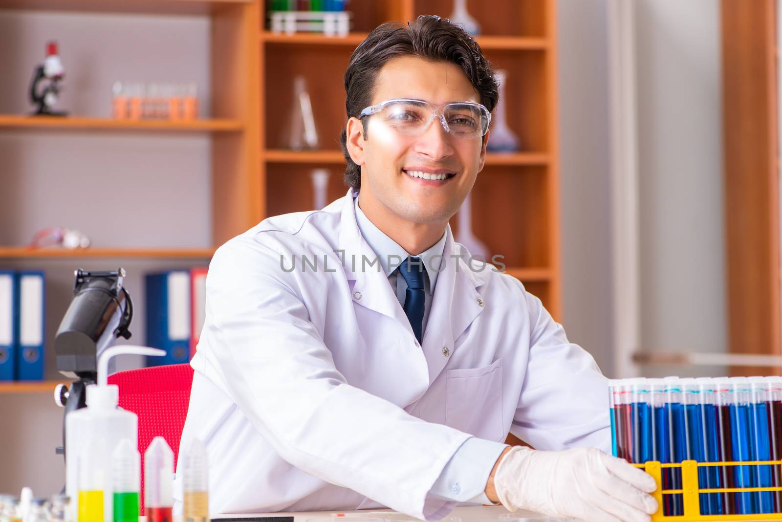 Young handsome biochemist working in the lab  