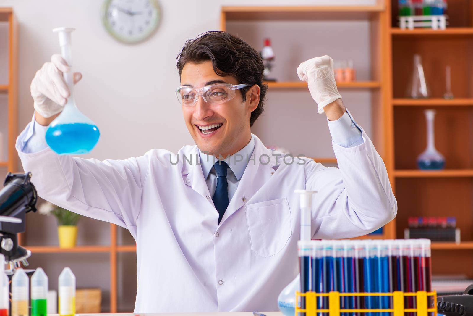 Young handsome biochemist working in the lab 