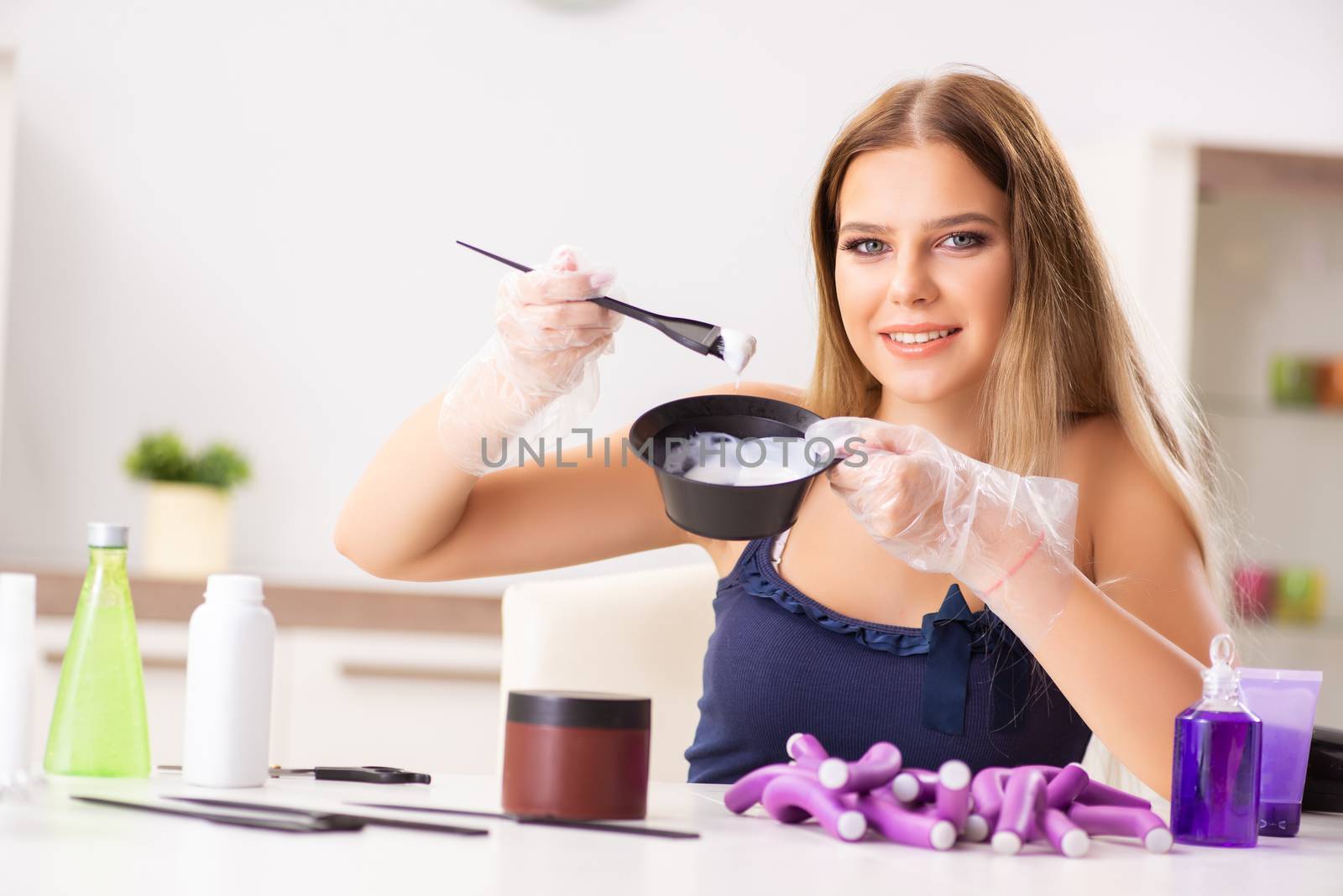 Young woman with hair curlers at barbershop 