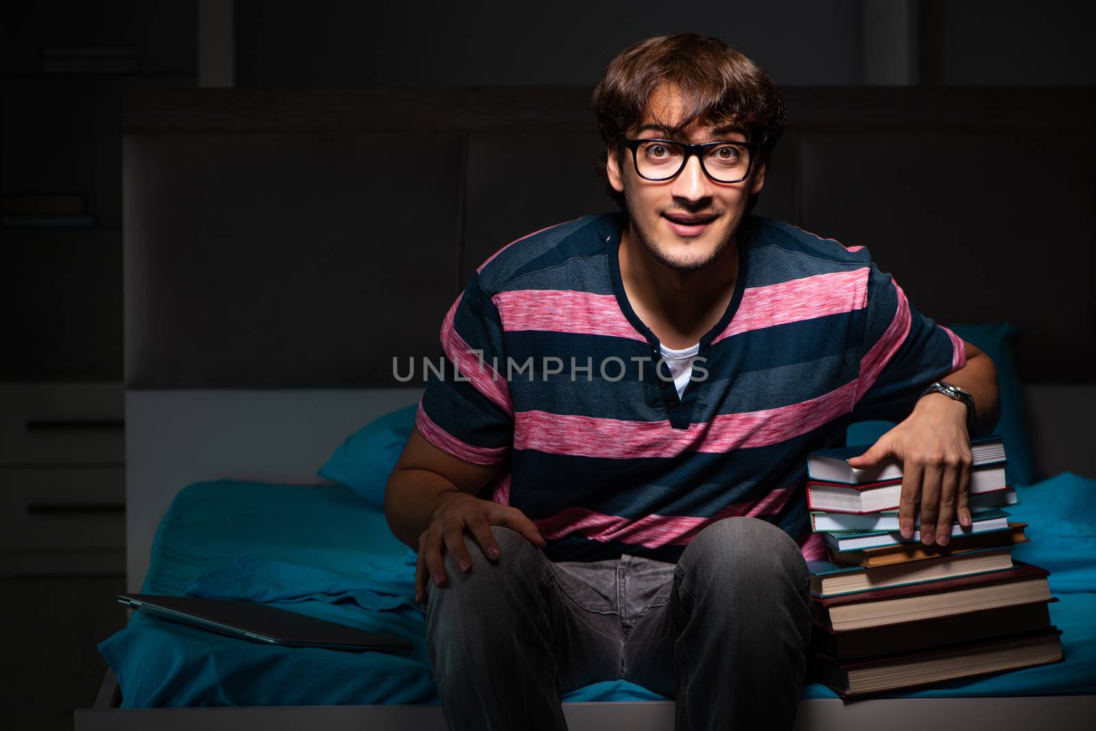 Young handsome student preparing for exams at night by Elnur