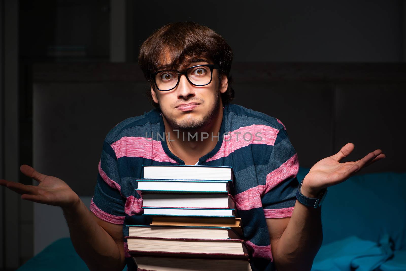 Young handsome student preparing for exams at night