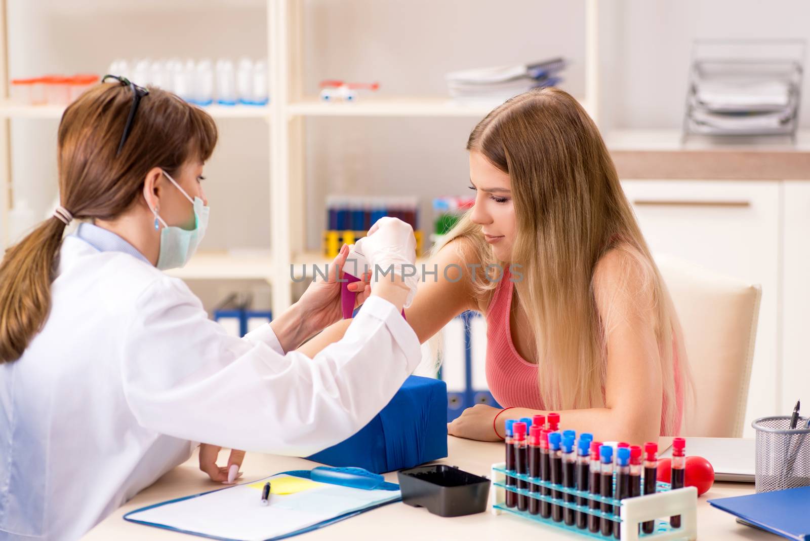 Young beautiful woman during blood test sampling procedure  