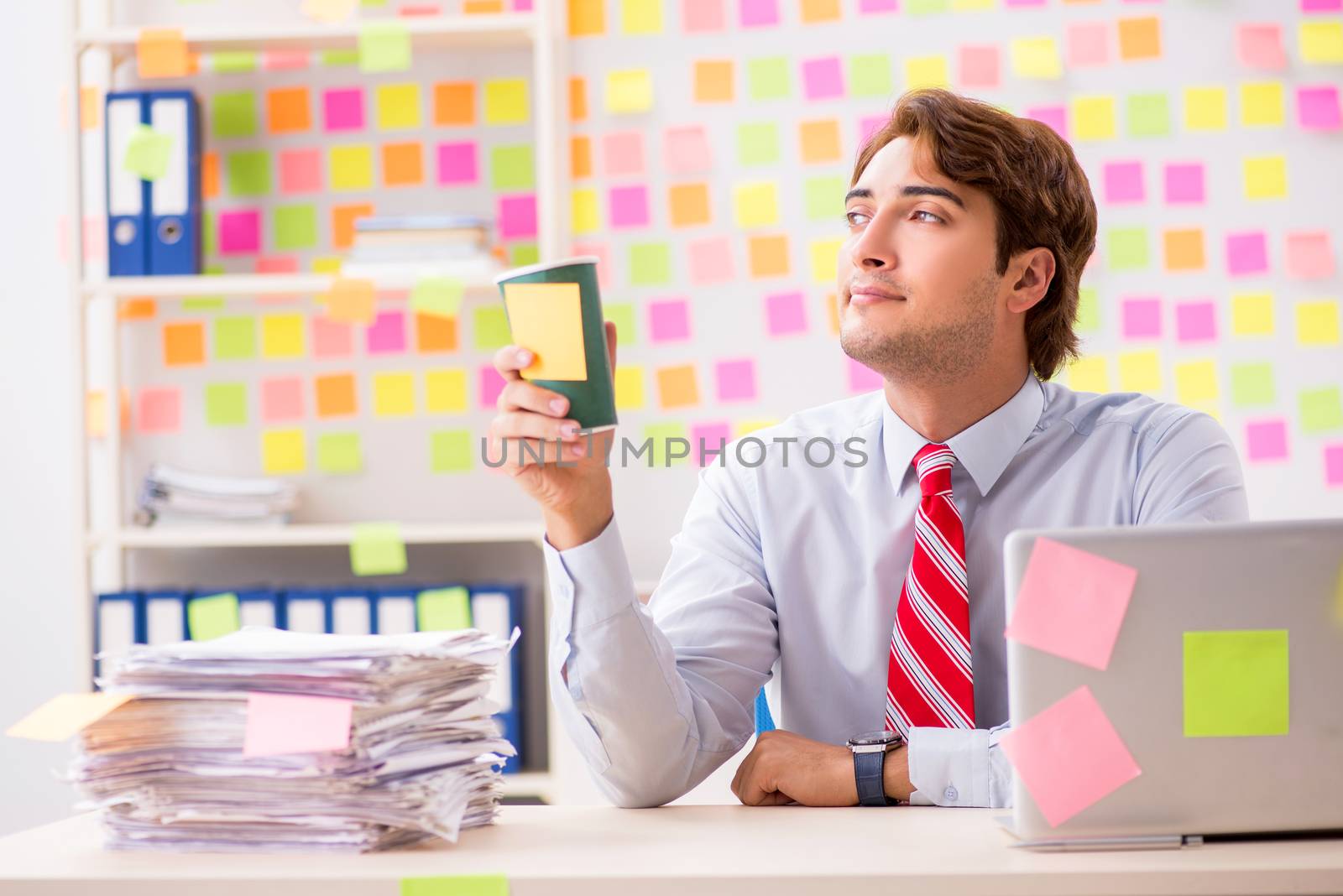 Young handsome man in conflicting priorities concept