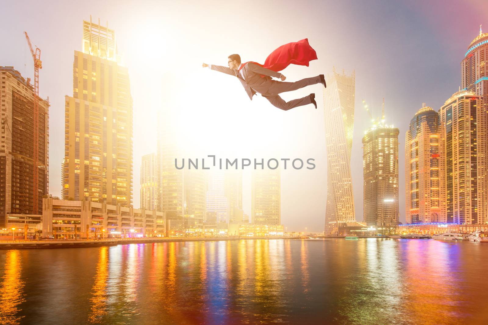 Superhero businessman flying over the city