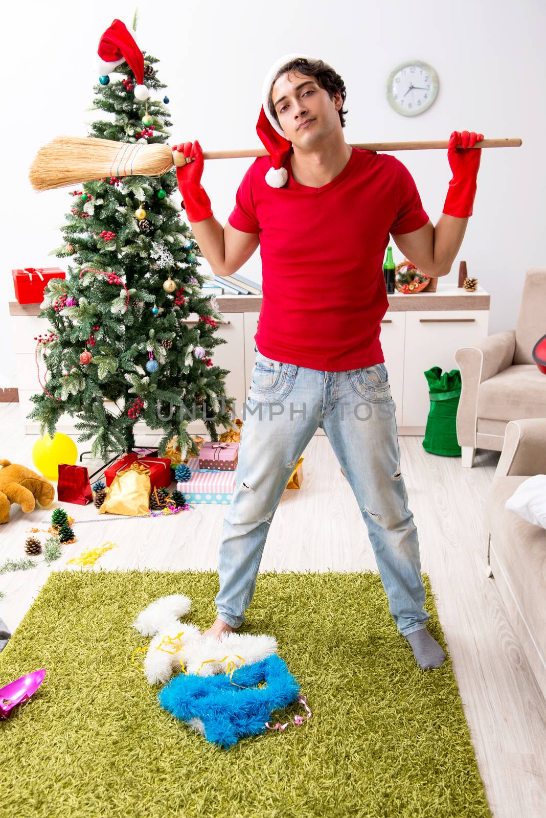 Man cleaning his apartment after christmas party by Elnur