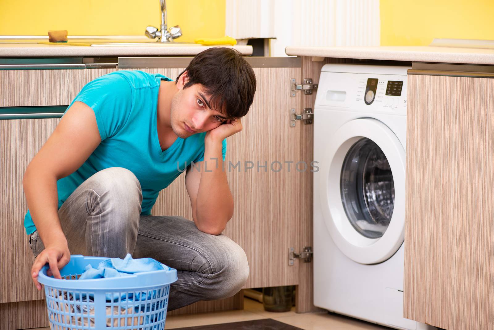 Young husband man doing laundry at home