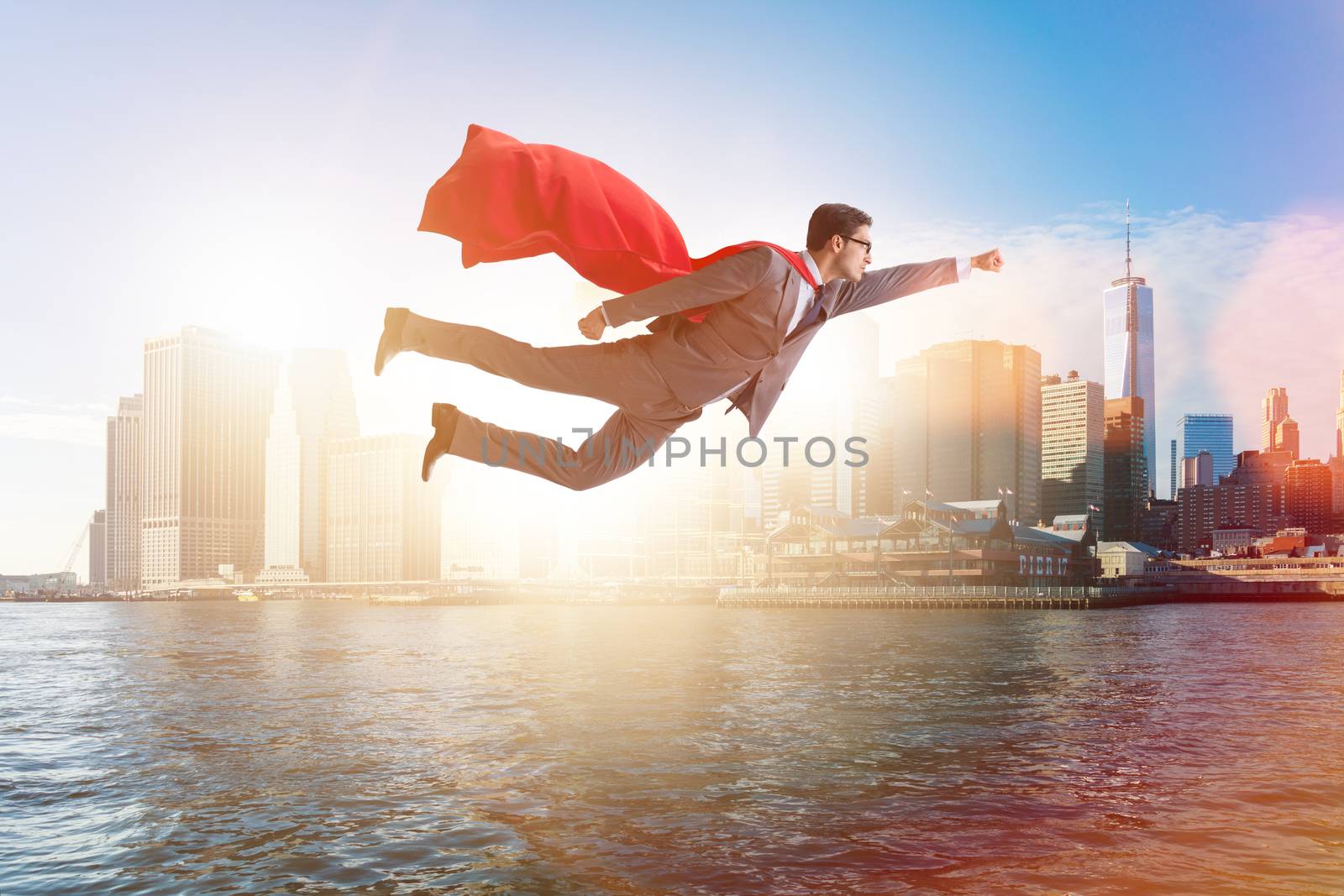 Superhero businessman flying over the city