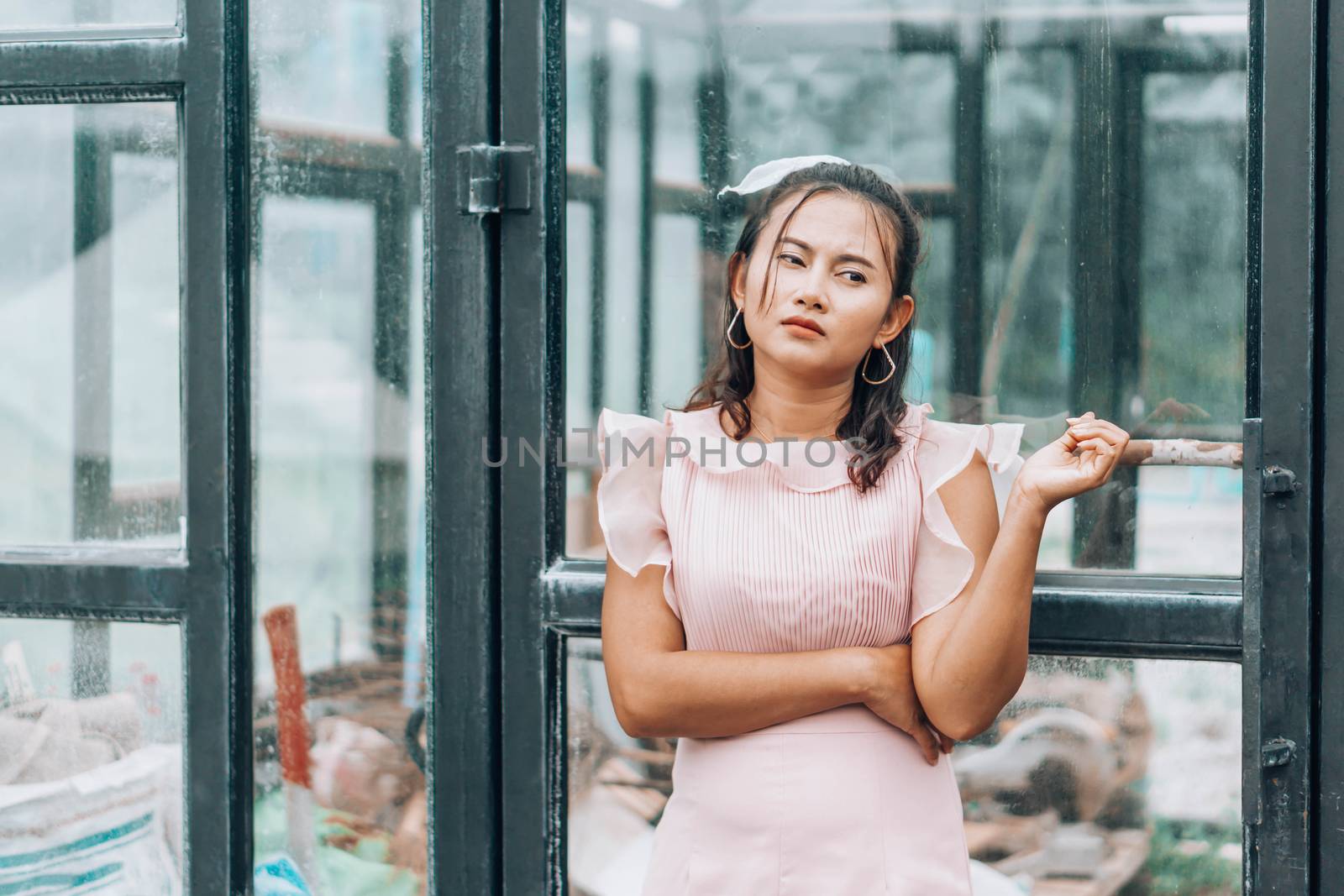 Portrait of asian woman posting and looking camera with glass house