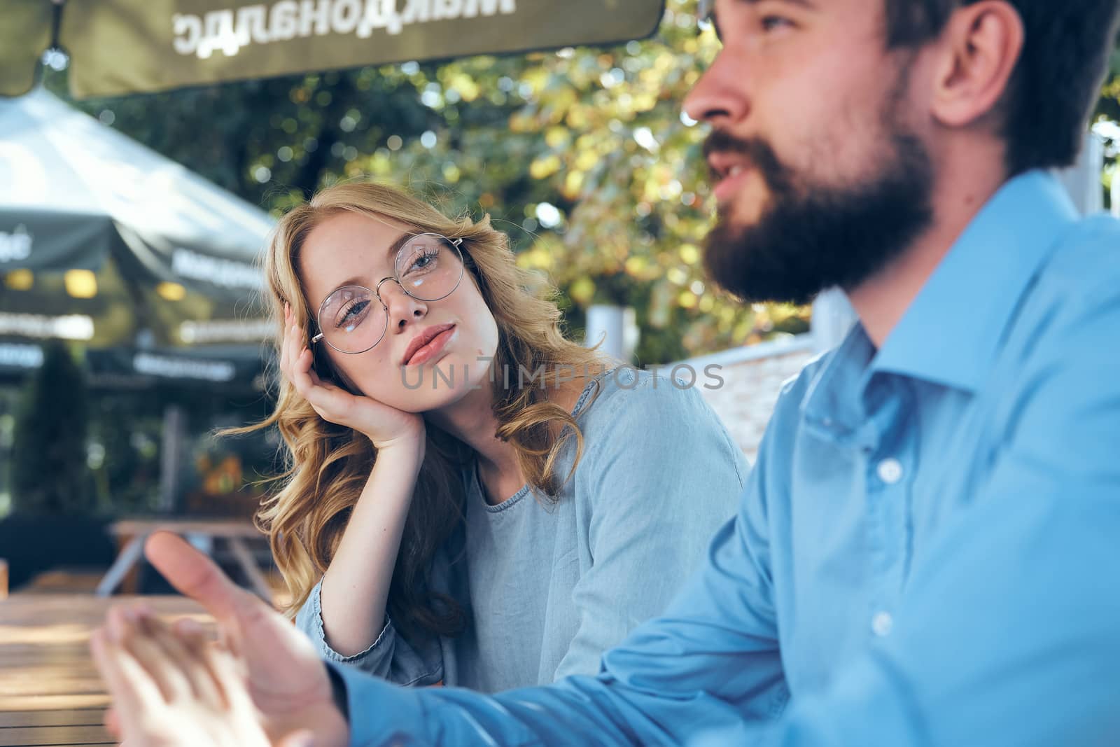 Man and woman communicate in the park outdoors in blue shirts employees friends work by SHOTPRIME