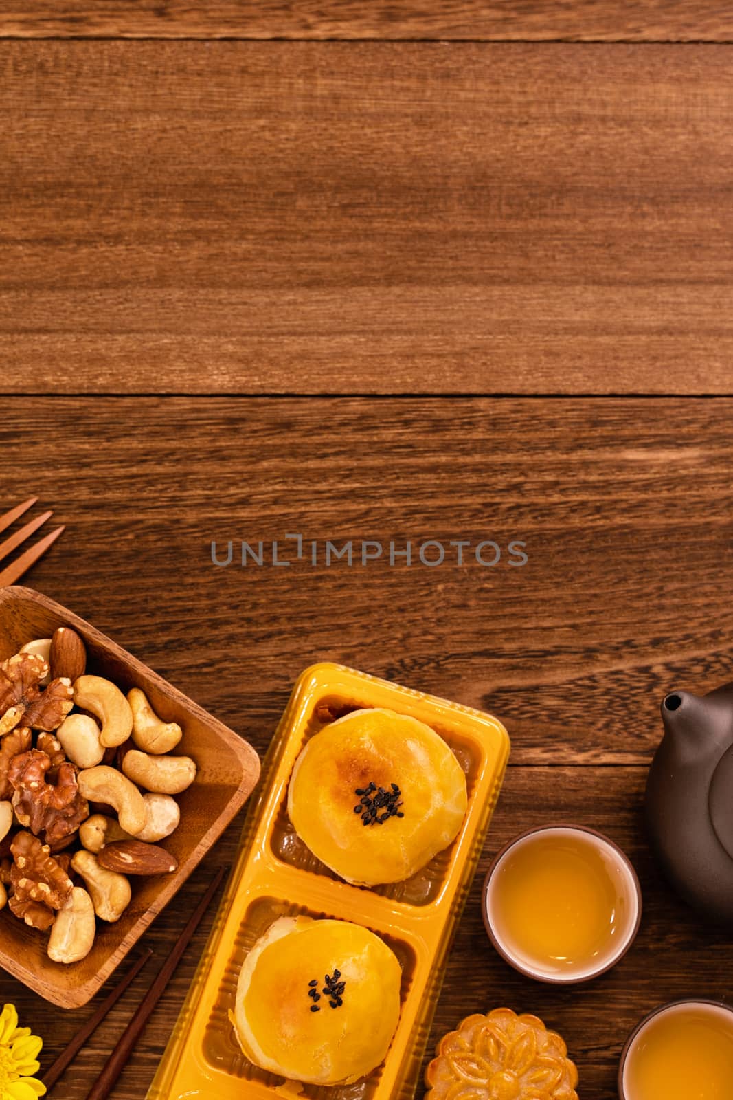 Moon cake for Mid-Autumn Festival, delicious beautiful fresh mooncake on a plate over dark wooden background table, top view, flat lay layout design concept.