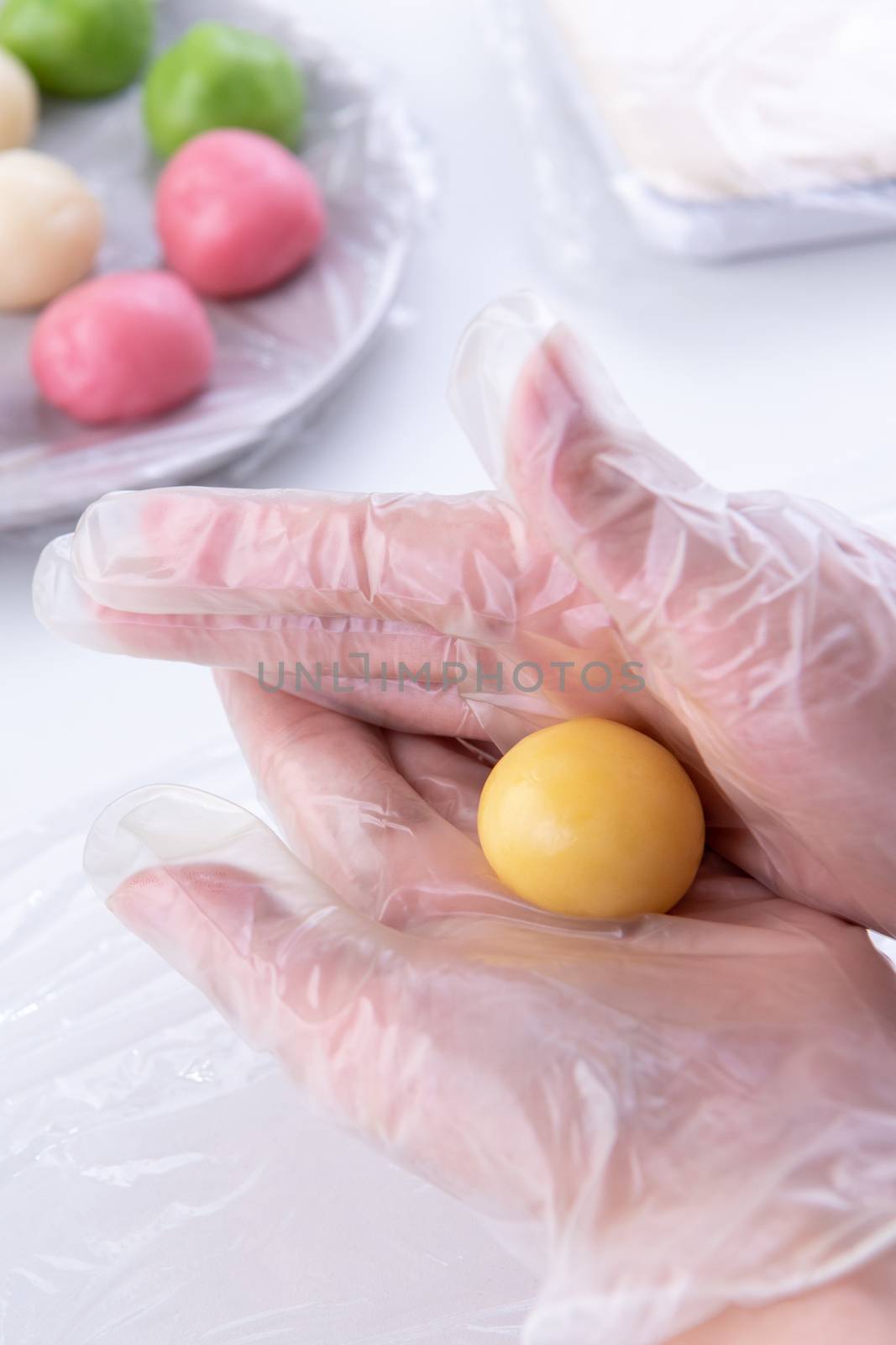 Young woman is making colorful snow skin moon cake, recipe of sw by ROMIXIMAGE