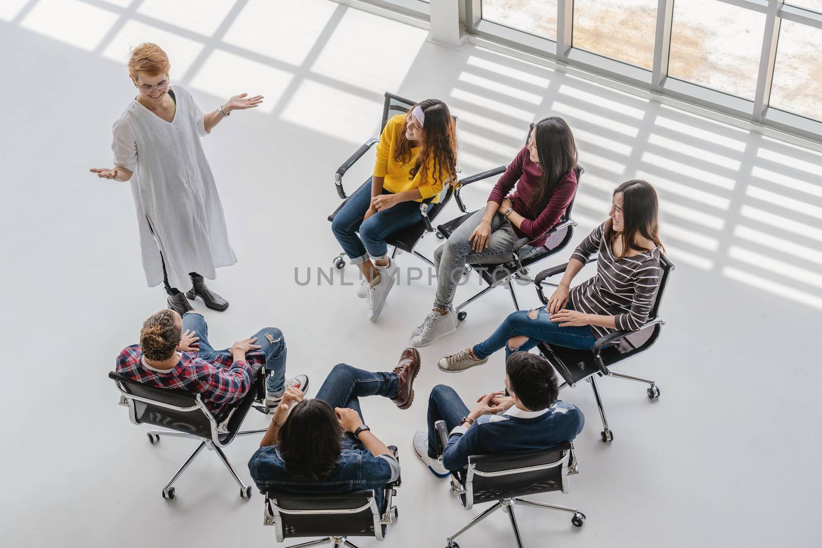 Top view of Asian senior manager woman presenting the creative ideas in front of Group Of Asian and Multiethnic Business people with casual suit in happy action in the modern workplace