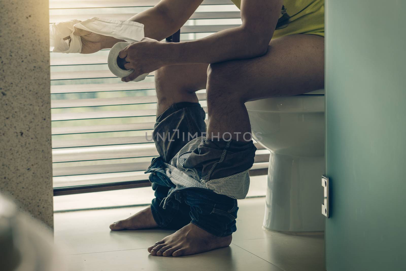 Man using the Tissue when sitting on toilet bowl by Tzido