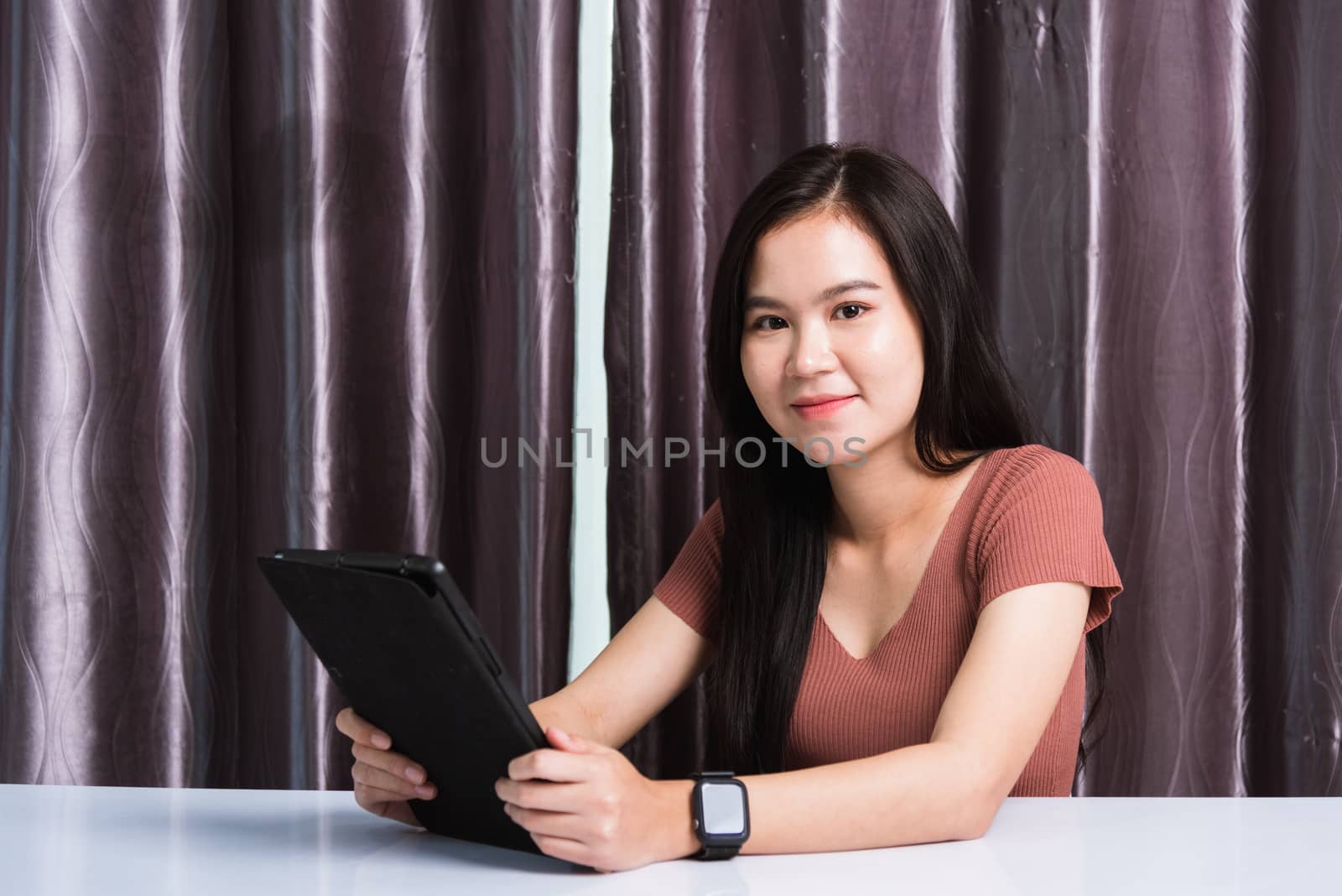 Work from home, Happy Asian business young beautiful woman sitting on desk workspace video call conferencing, write, check or read mail on digital tablet computer technology at home office