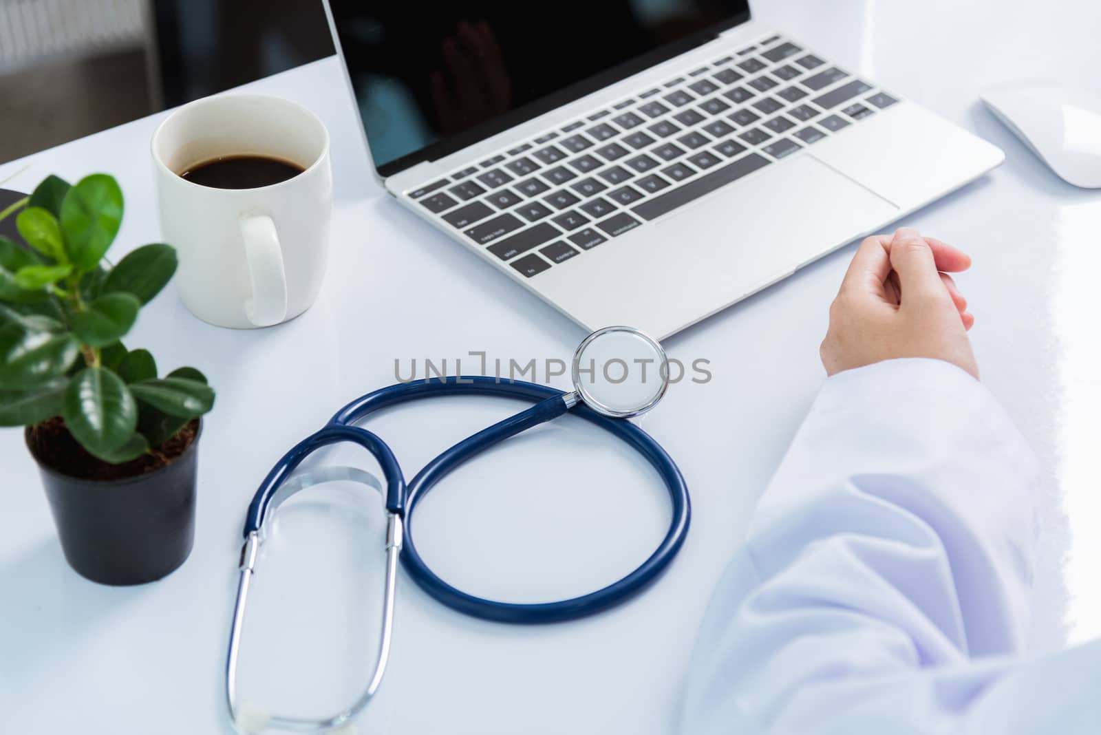 Medicine doctor's working on desk. Closeup of Stethoscope. Hand of Asian woman physician explain to patients on table front laptop computer at the hospital office, Healthcare medic concept