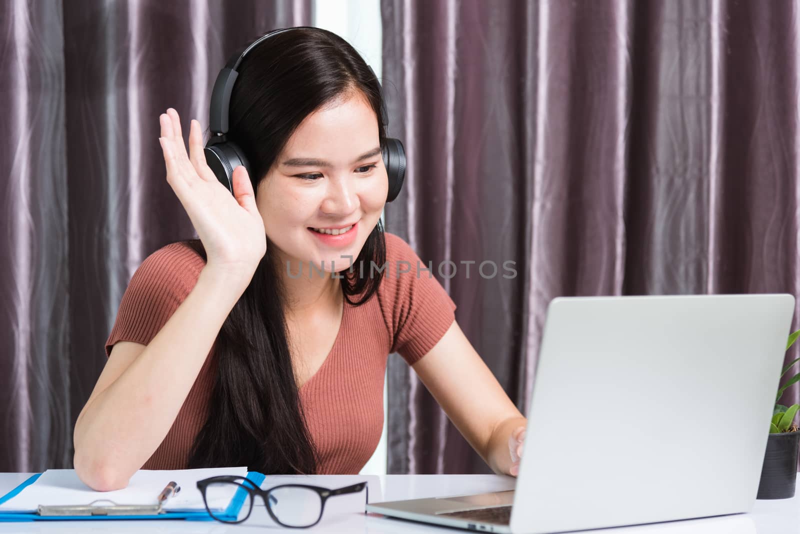 Business woman wearing headphones video call conference by Sorapop