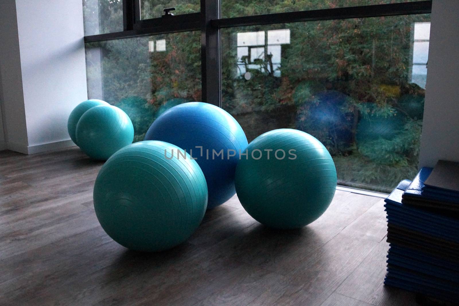 fitness balls by the window in the gym close up by Annado