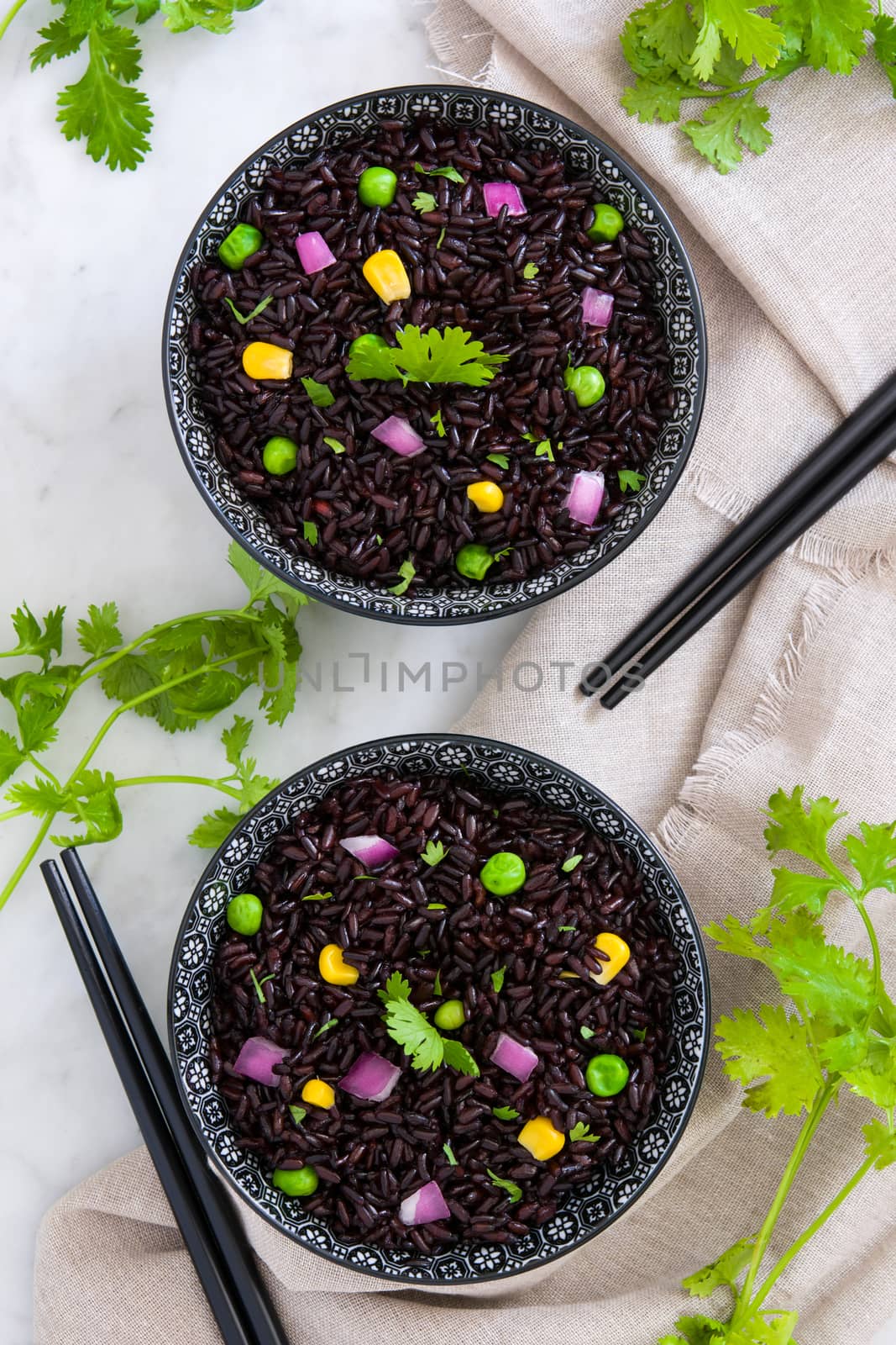 Black rice in a bowl and vegetables by chandlervid85