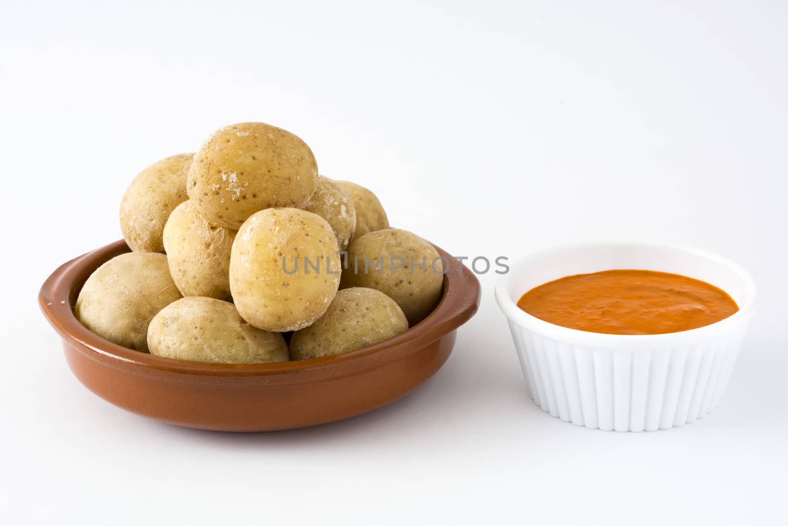 Canarian potatoes (papas arrugadas) with mojo sauce isolated on white background by chandlervid85