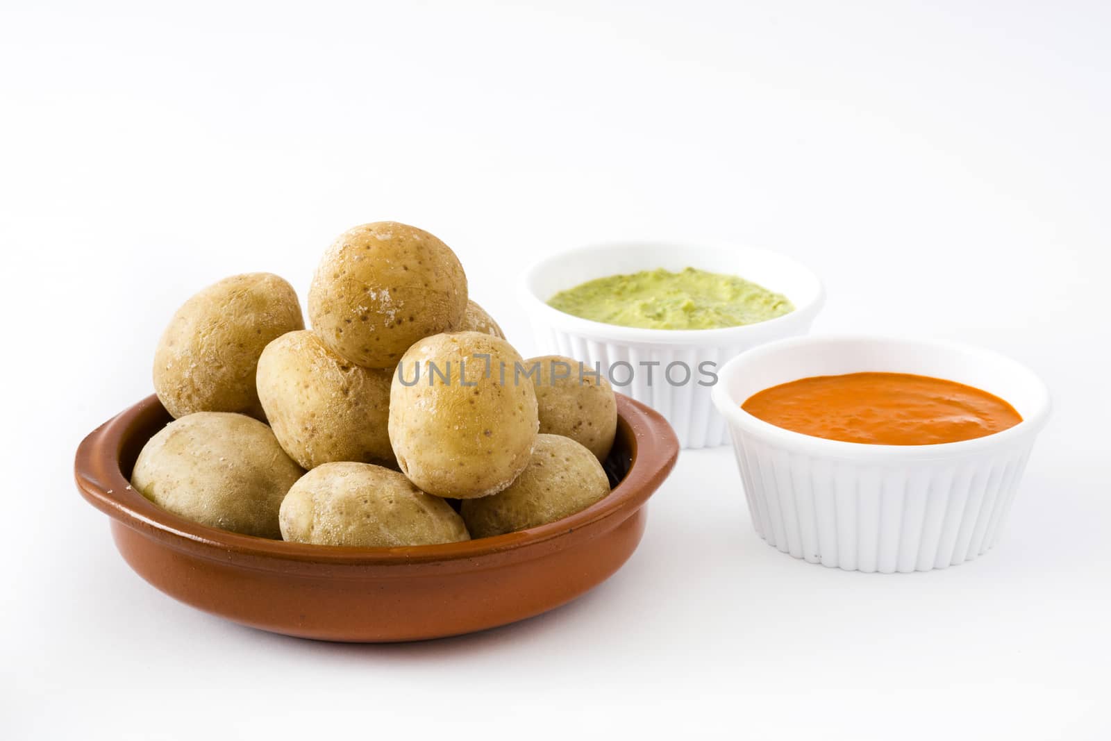 Canarian potatoes (papas arrugadas) with mojo sauce isolated on white background