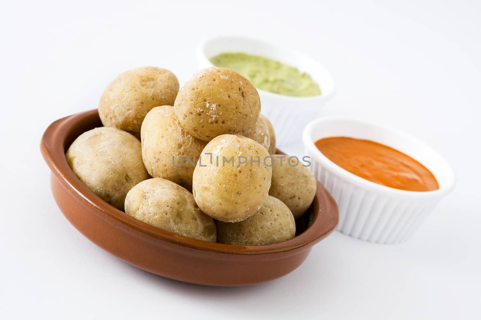Canarian potatoes (papas arrugadas) with mojo sauce isolated on white background