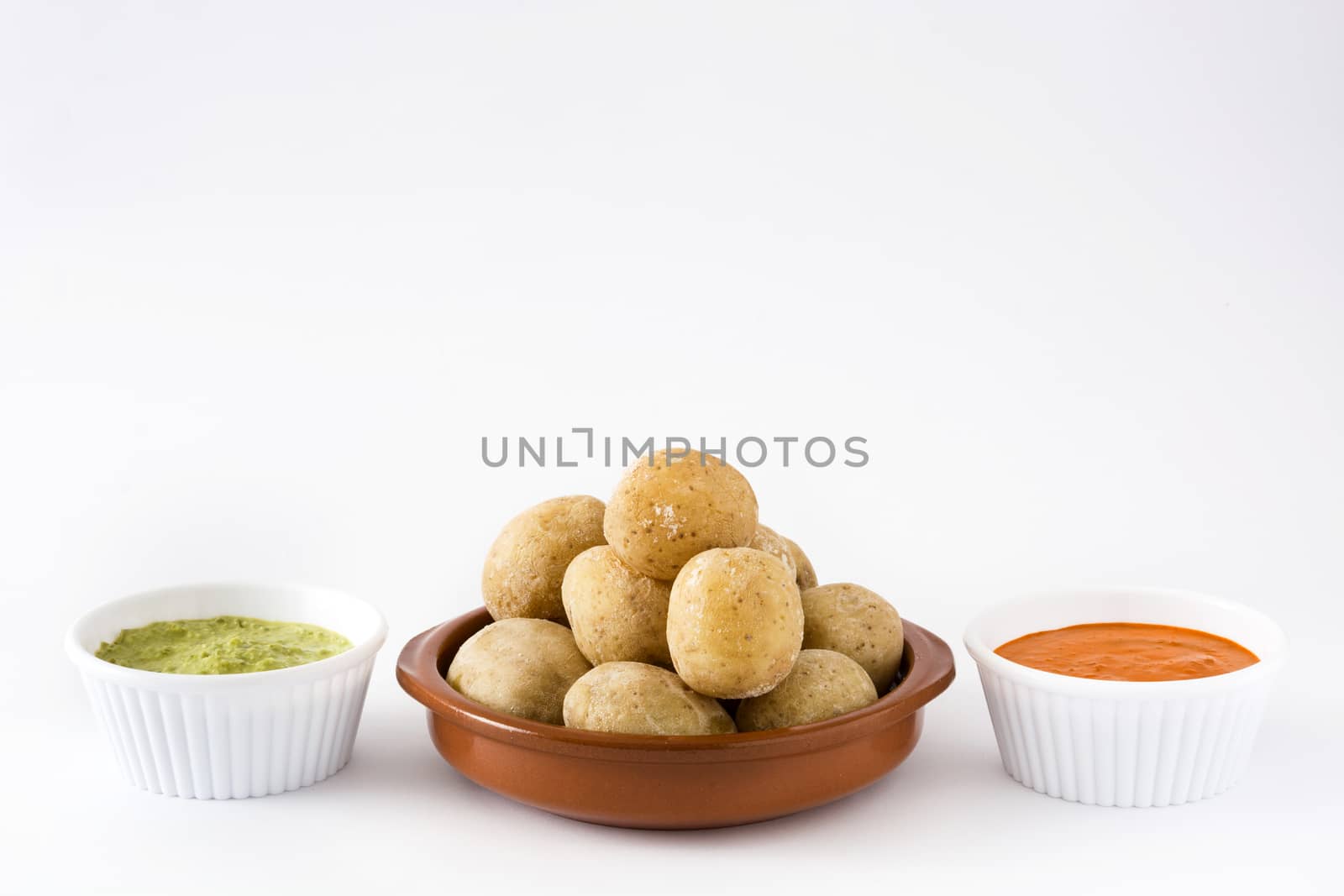 Canarian potatoes (papas arrugadas) with mojo sauce isolated on white background by chandlervid85