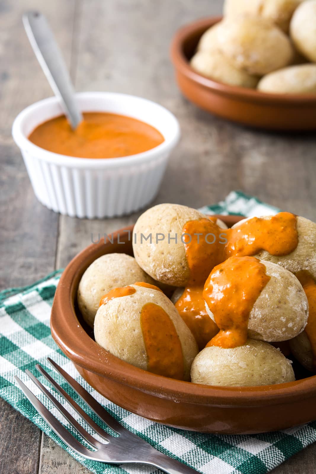 Canarian potatoes (papas arrugadas) with mojo sauce on wooden table by chandlervid85