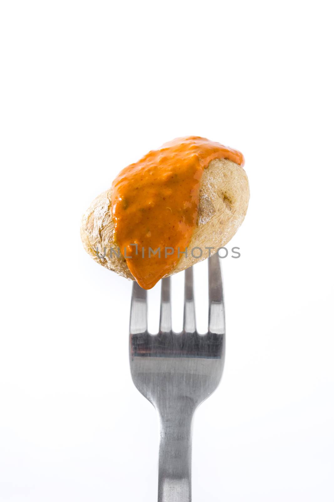 Canarian potato (papa arrugada) with mojo sauce on a fork isolated on white background by chandlervid85