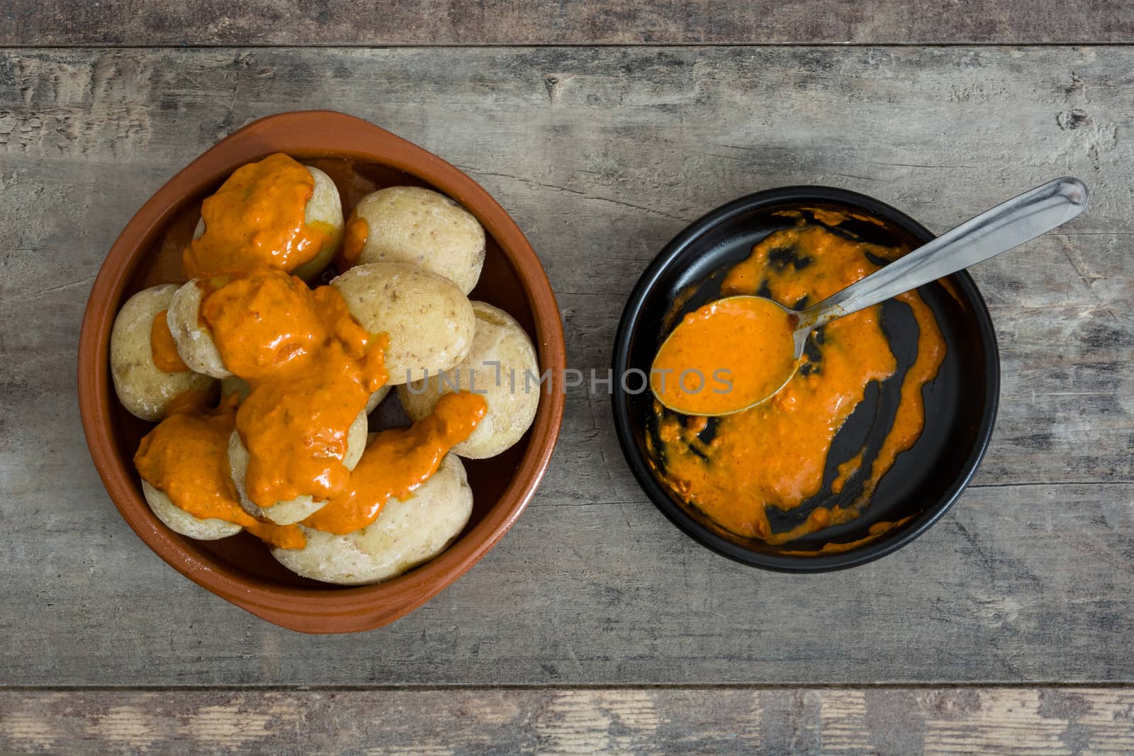 Canarian potatoes (papas arrugadas) with mojo sauce on wooden table