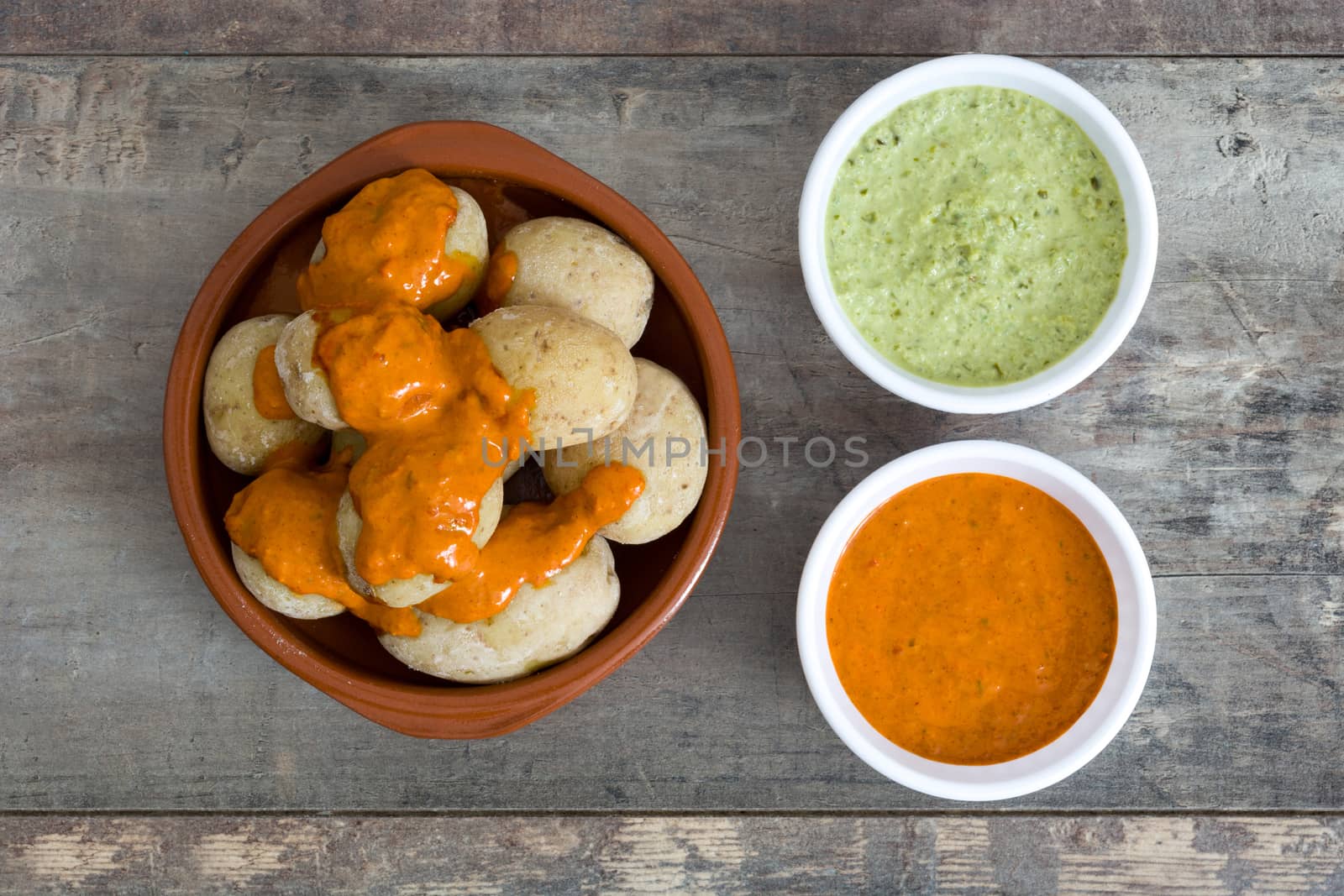 Canarian potatoes (papas arrugadas) with mojo sauce on wooden table