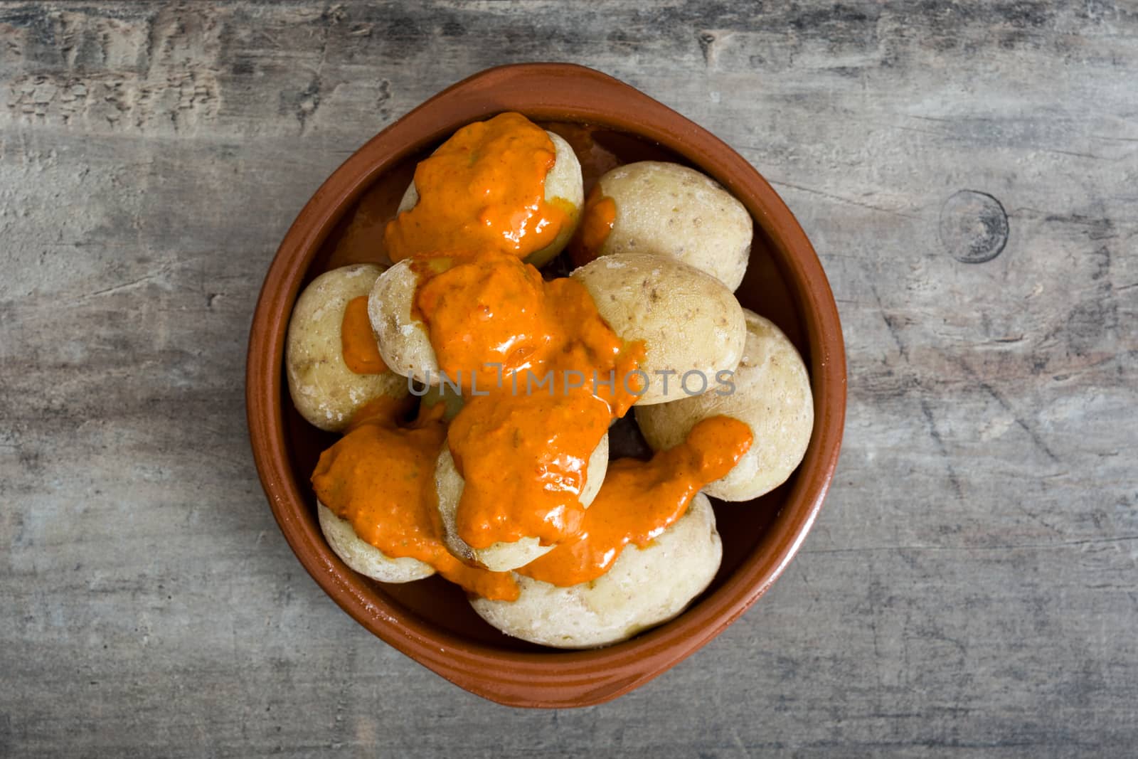 Canarian potatoes (papas arrugadas) with mojo sauce on wooden table