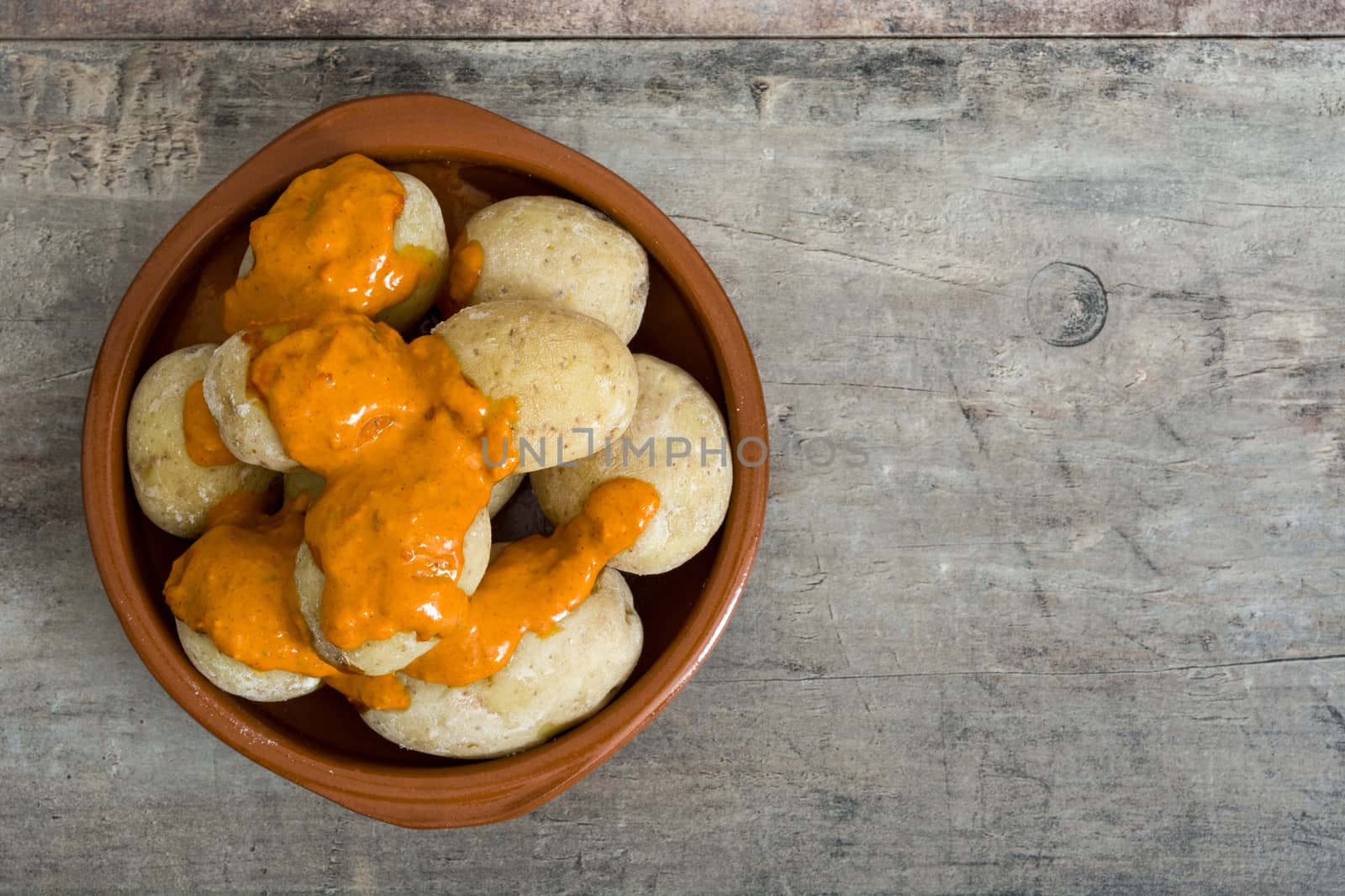 Canarian potatoes (papas arrugadas) with mojo sauce on wooden table by chandlervid85