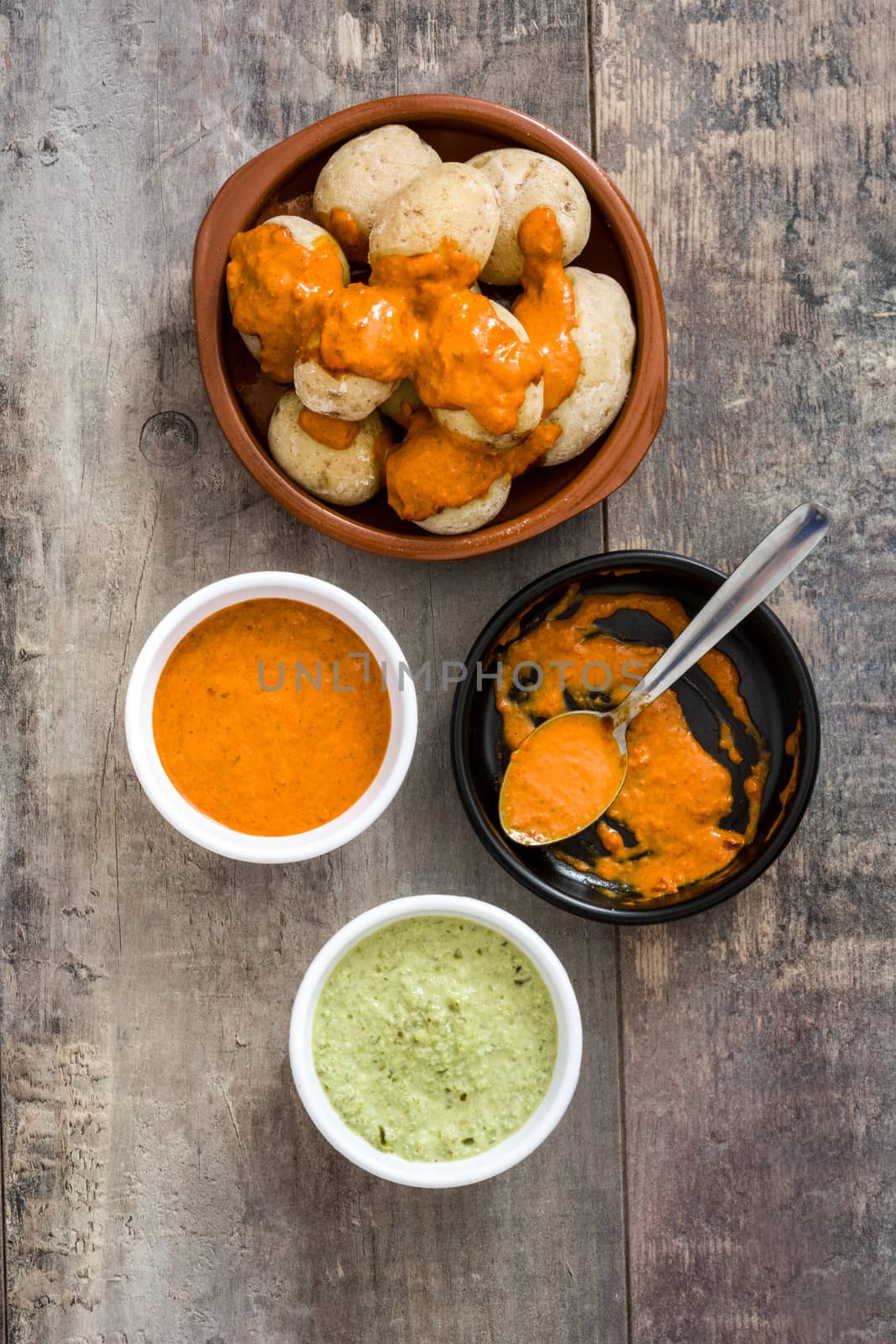 Canarian potatoes (papas arrugadas) with mojo sauce on wooden table by chandlervid85