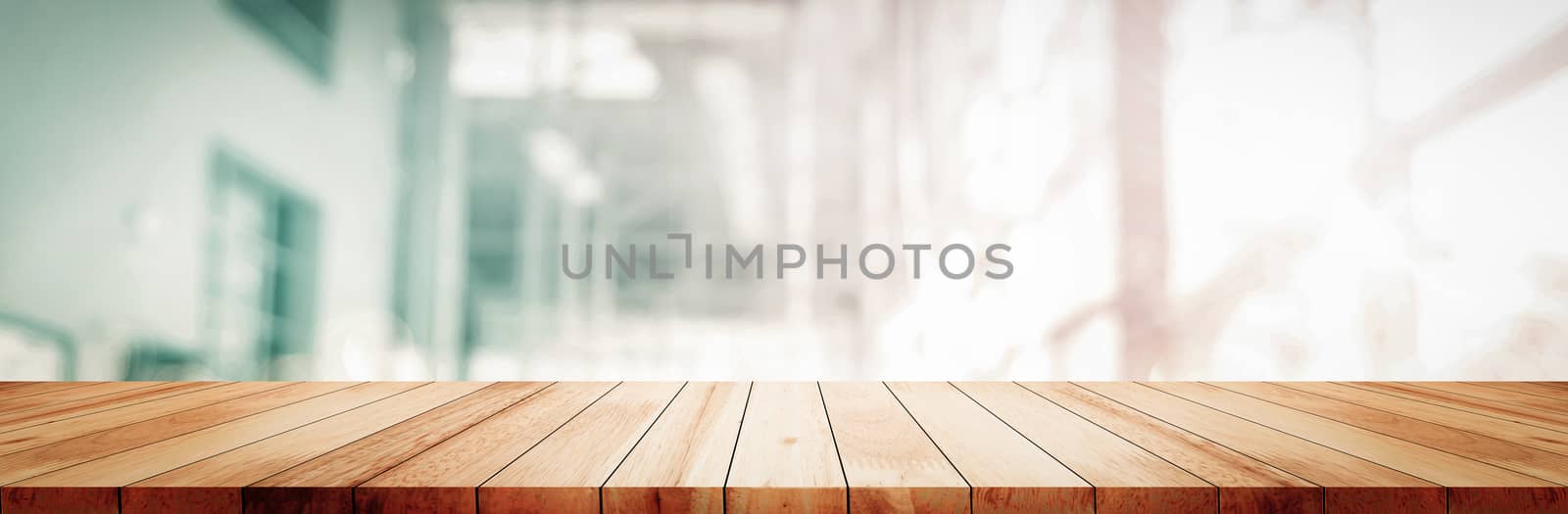 Panoramic empty clean wood counter table top on blur glass window white light background for product morning scene display montage, Abstract Blurry wide modern wooden desk in kitchen room backdrop.
