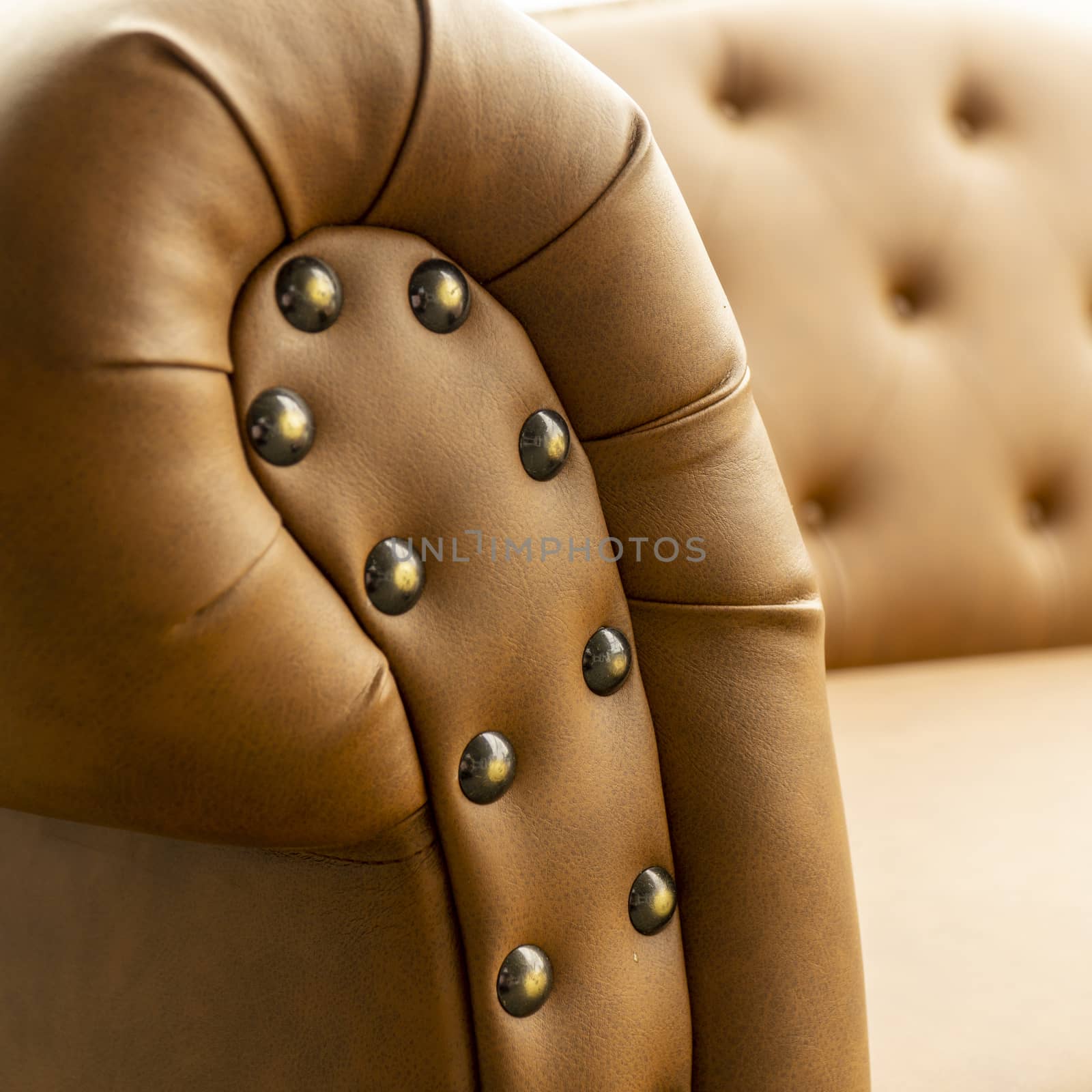 Close up of pins and buttons on a vintage style sofa. Buttoned vintage sofa up close.