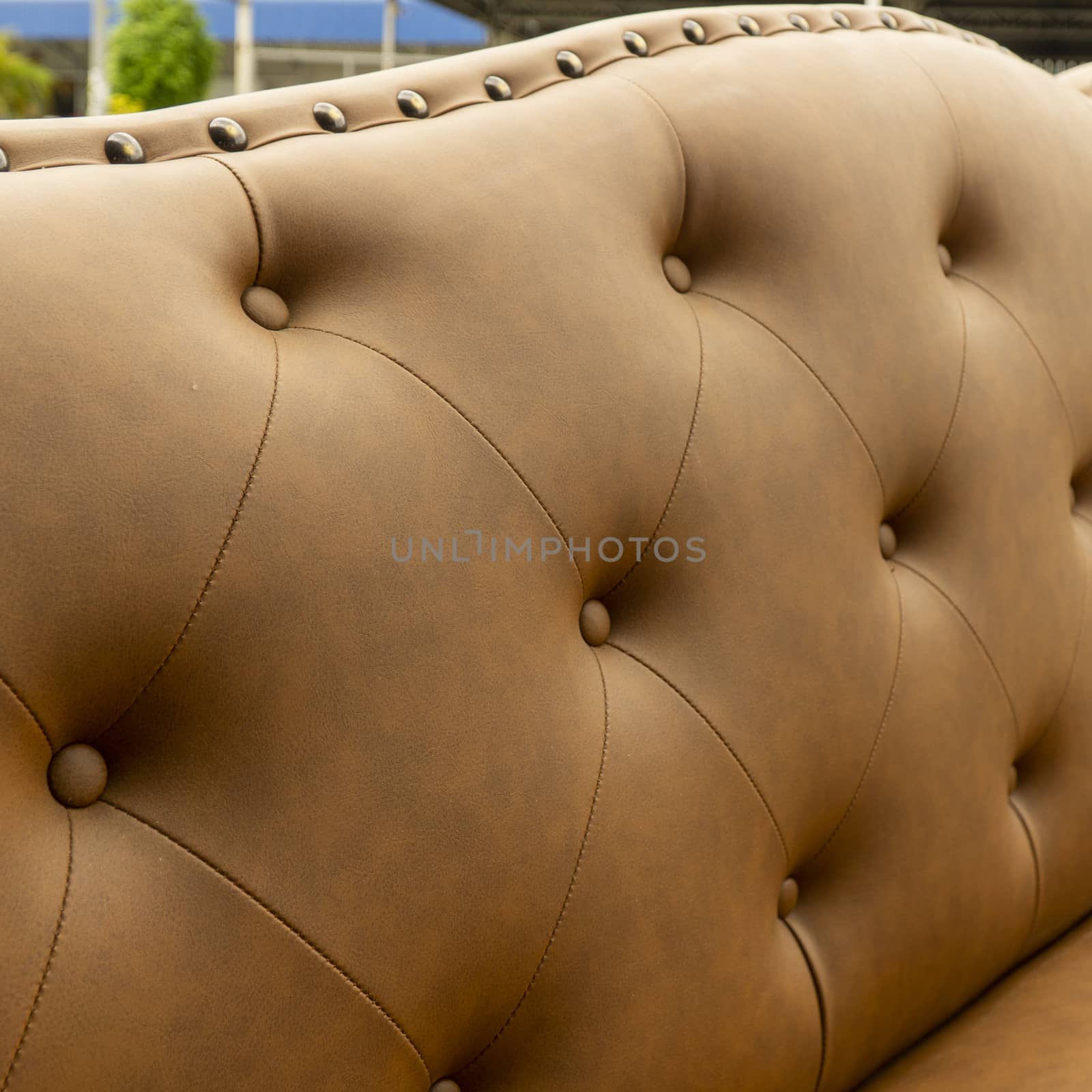 Close up of pins and buttons on a vintage style sofa. Buttoned vintage sofa up close.