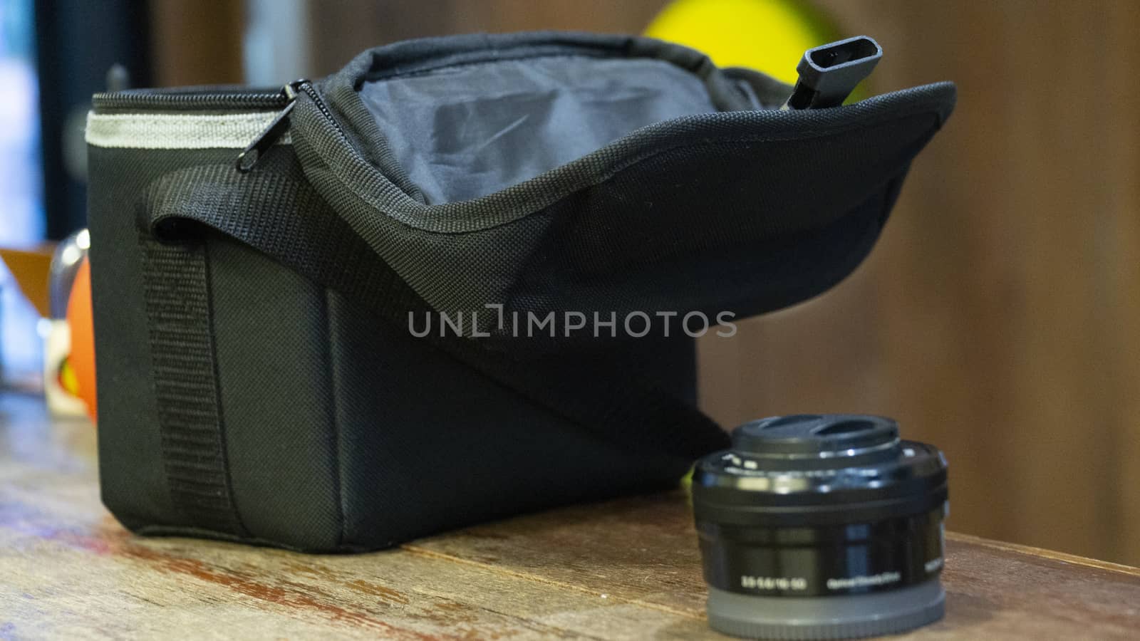 Camera lens beside a camera holder bag