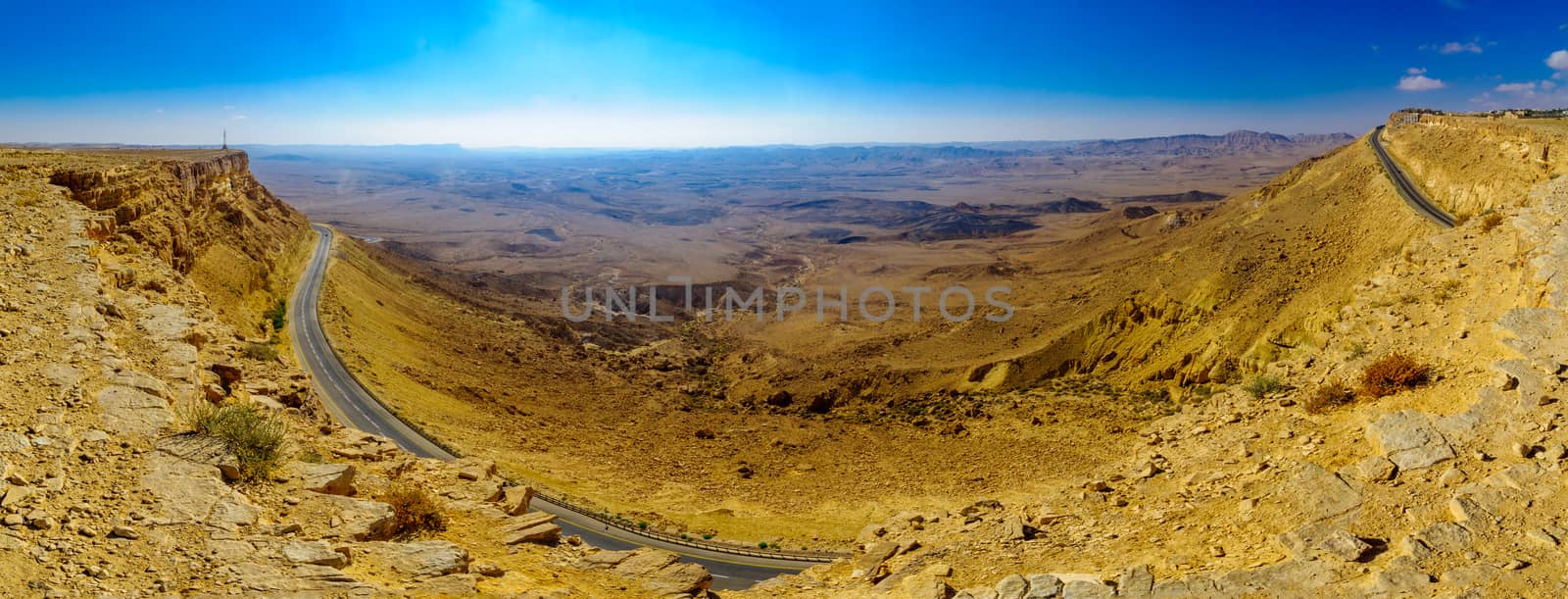 Panoramic view of cliffs, landscape, and road in Makhtesh (crater) Ramon, the Negev Desert, Southern Israel