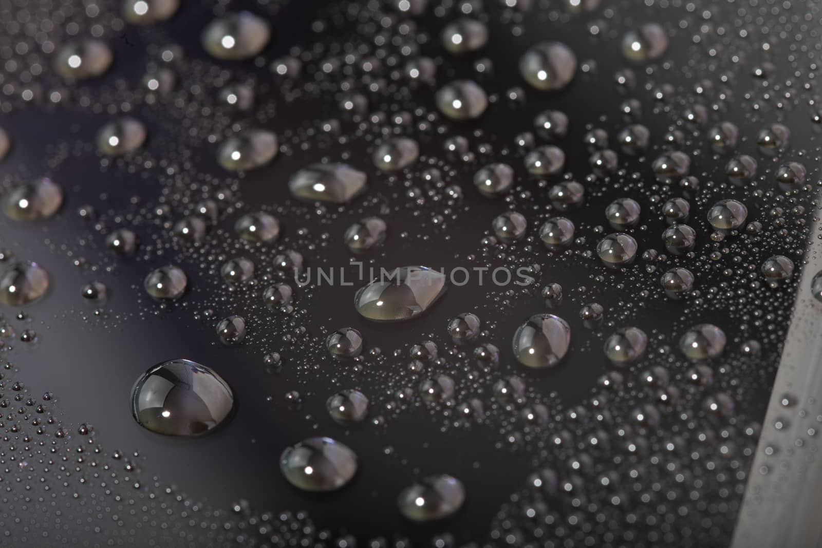 water drops on the surface of cellphone hydriphobic coated glass screen, close-up with selective focus and visible pixel grid
