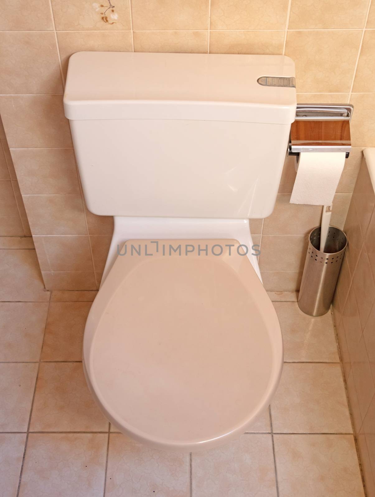 Very old toilet in a brown bathroom, empty