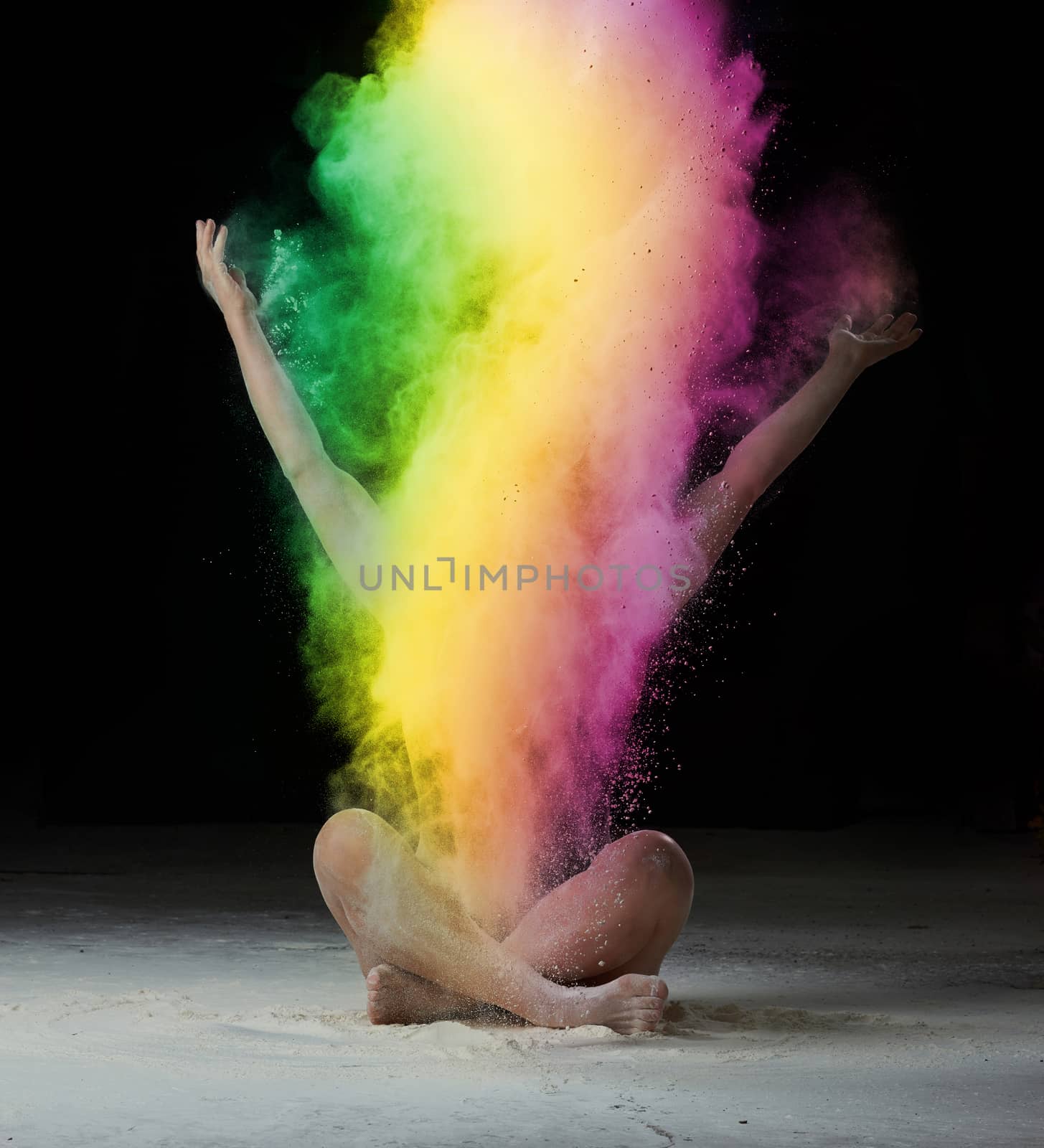 woman sits on the floor and throws colored powder up, black back by ndanko