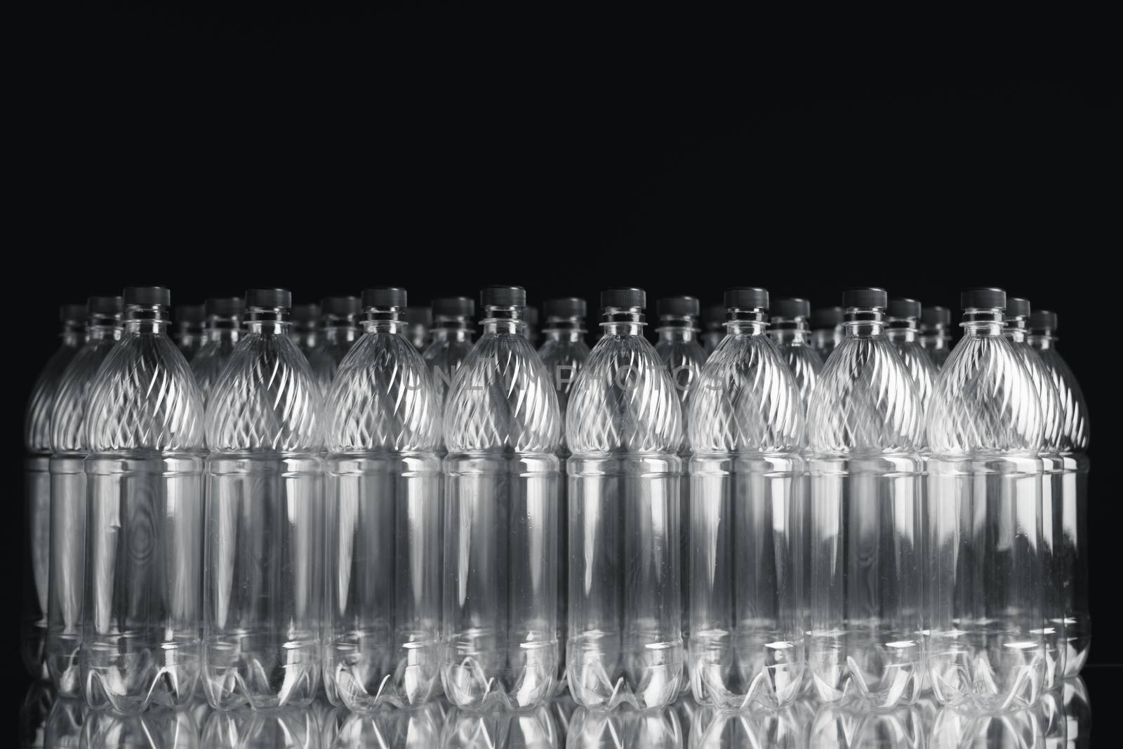 empty plastic bottles on black background by nikkytok